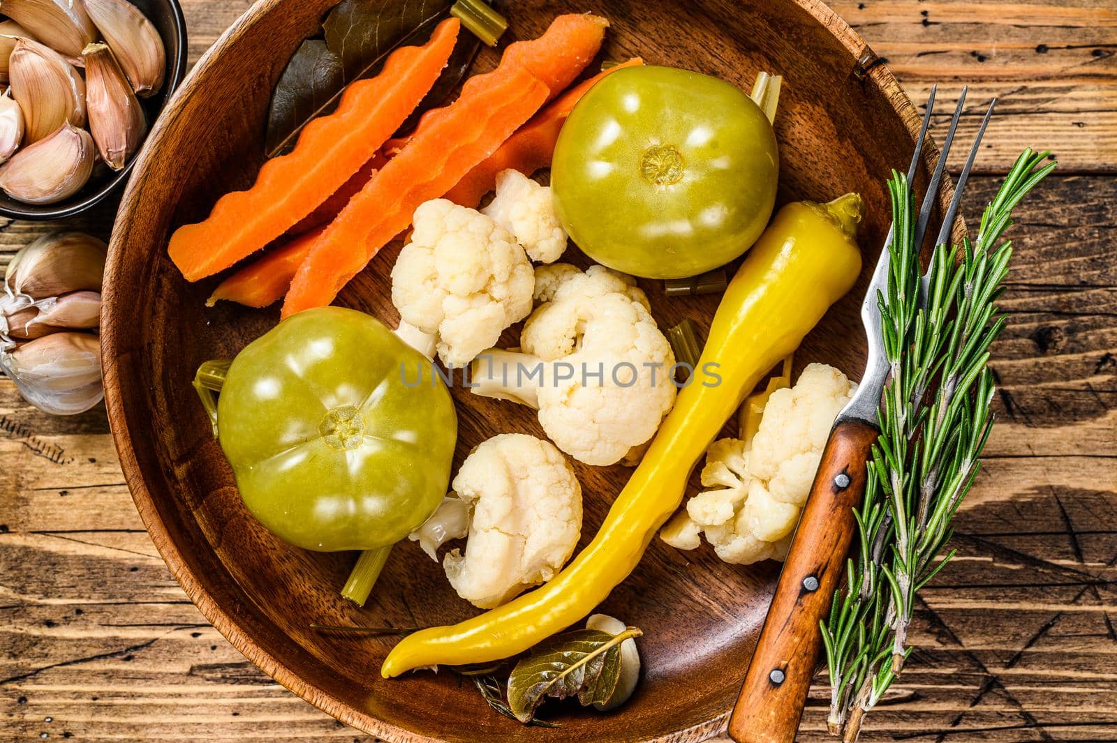 Salted and pickles vegetables preserve in a wooden plate. wooden background. Top view.