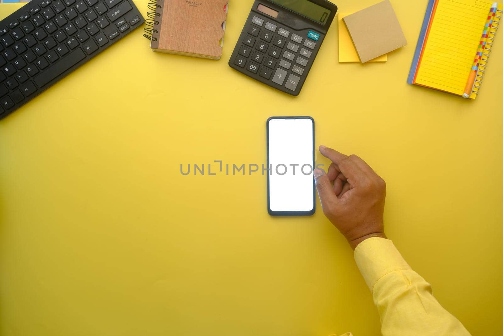 top view of man hand using smart phone on office desk.