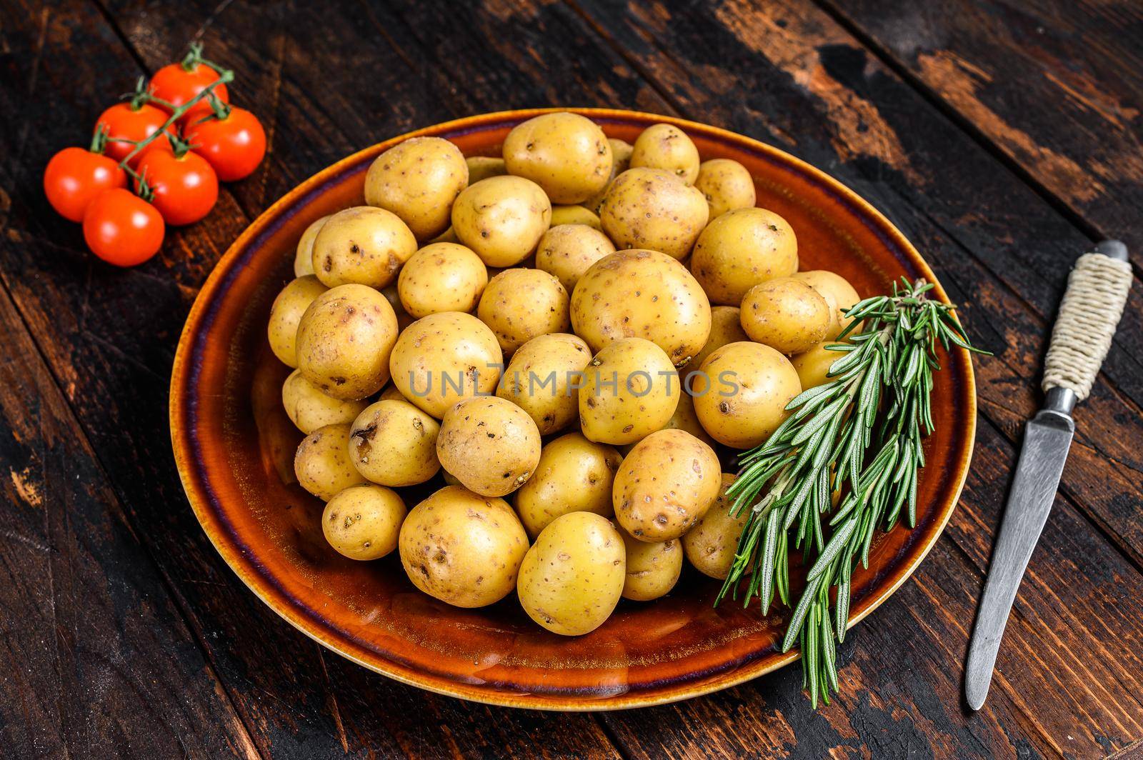 Raw baby mini Potatoes. Dark wooden background. Top view by Composter