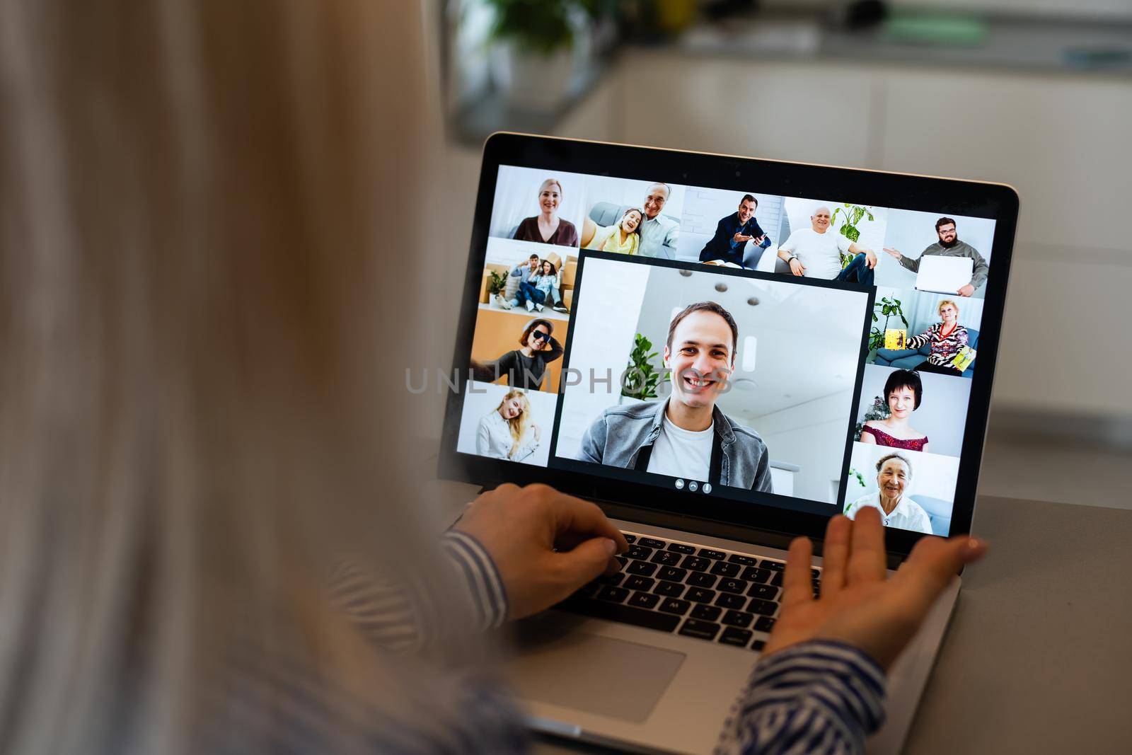 Back view of business woman talking to her colleagues about plan in video conference. Multiethnic business team using laptop for a online meeting in video call. Group of people smart working from home