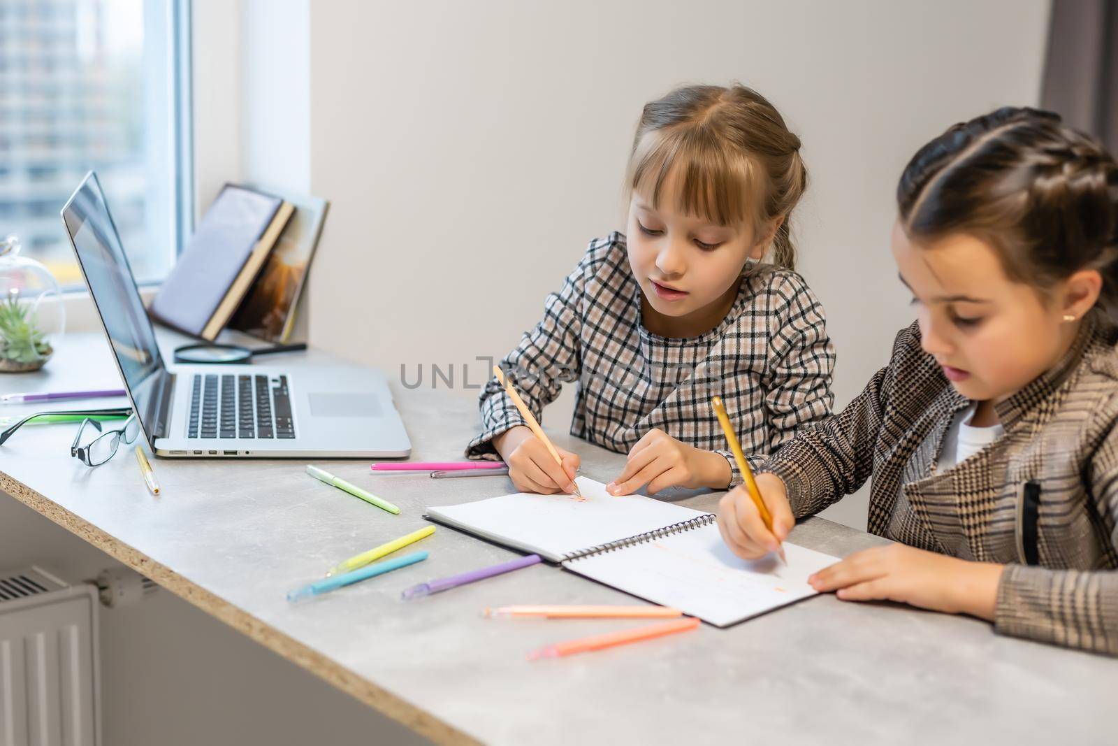 Two little girls doing their school homework by Andelov13