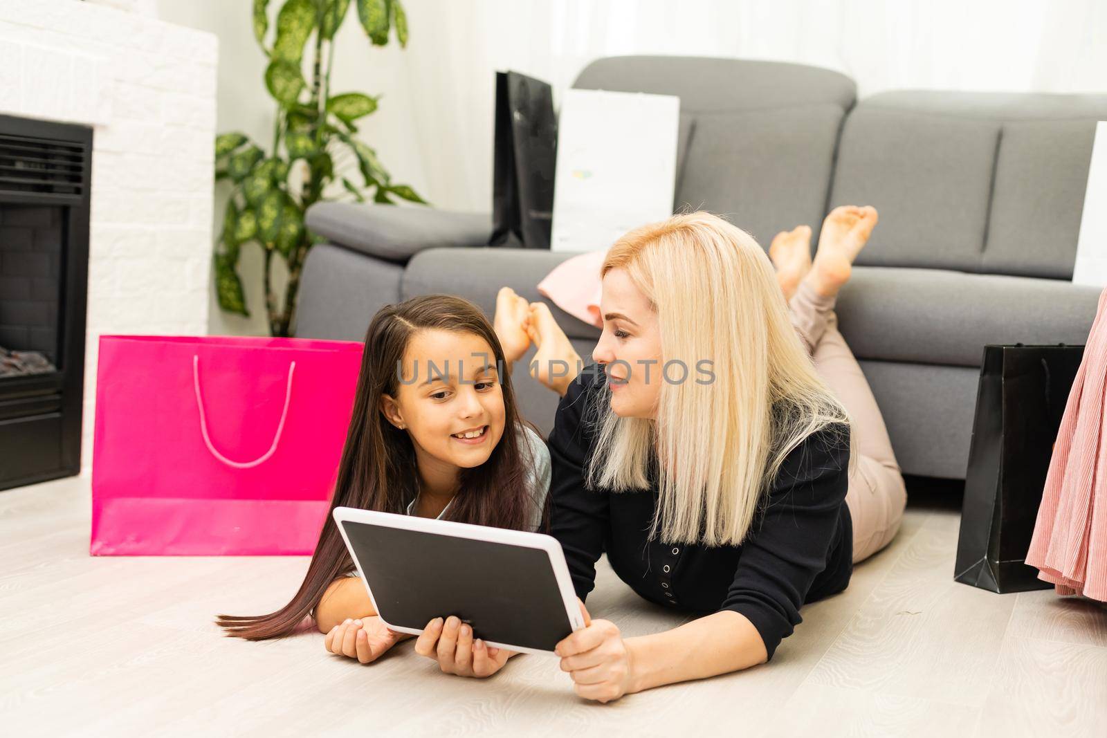 Mother and daughter is using tablet for buying thing online black Friday by Andelov13