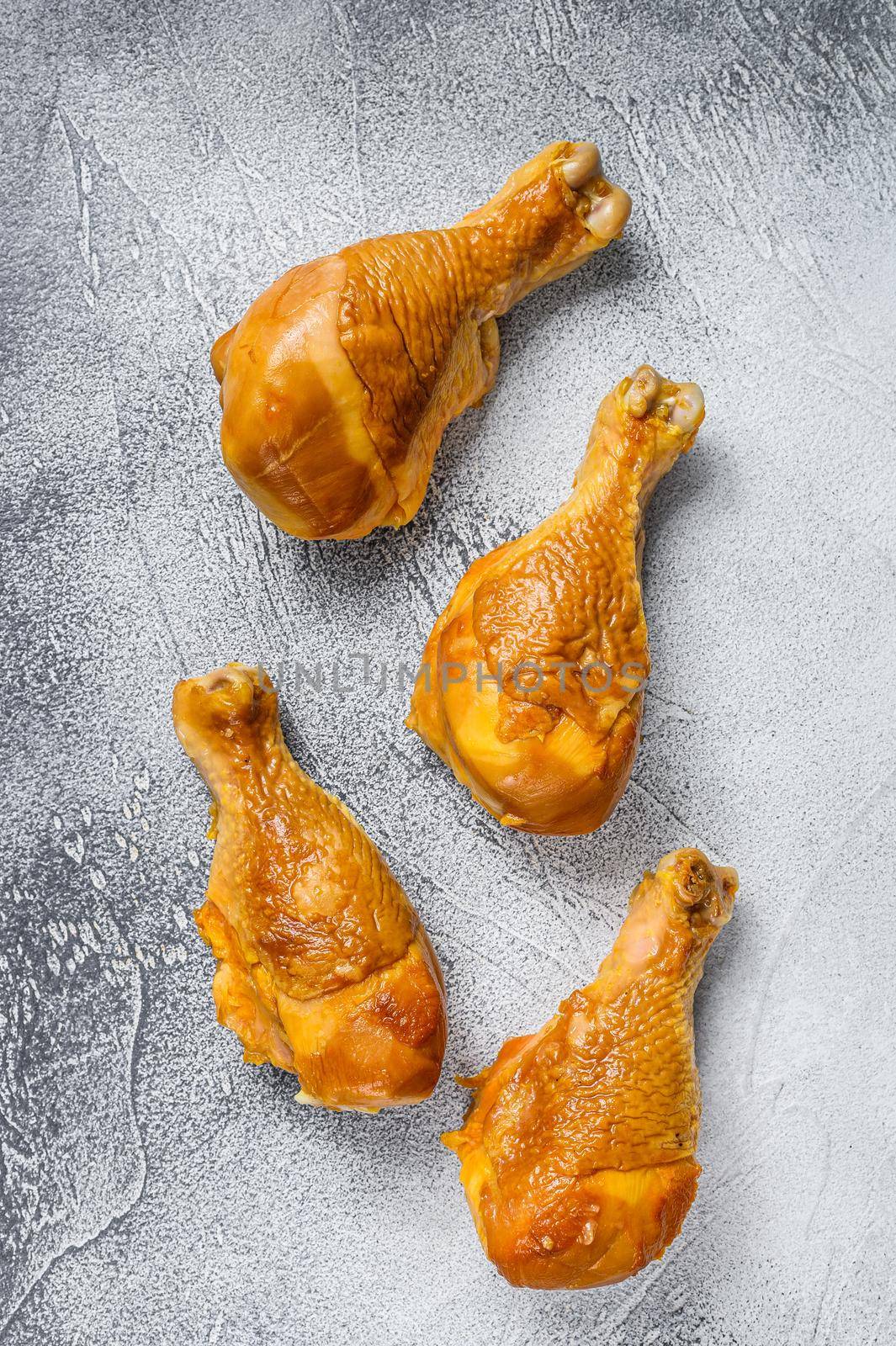 Smoked chicken leg drumsticks on a kitchen table. White background. Top view.