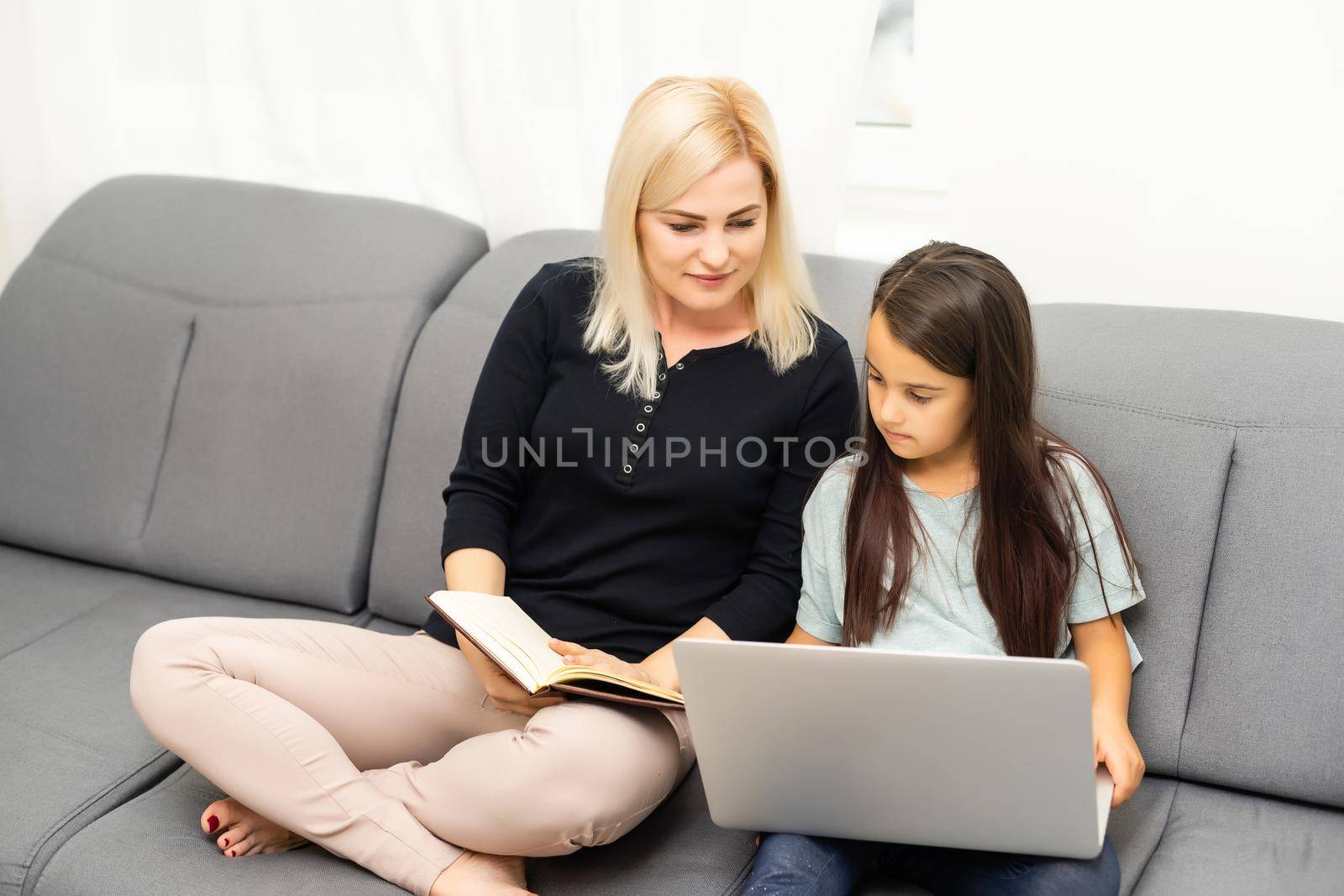 mother and daughter doing homework with a tablet