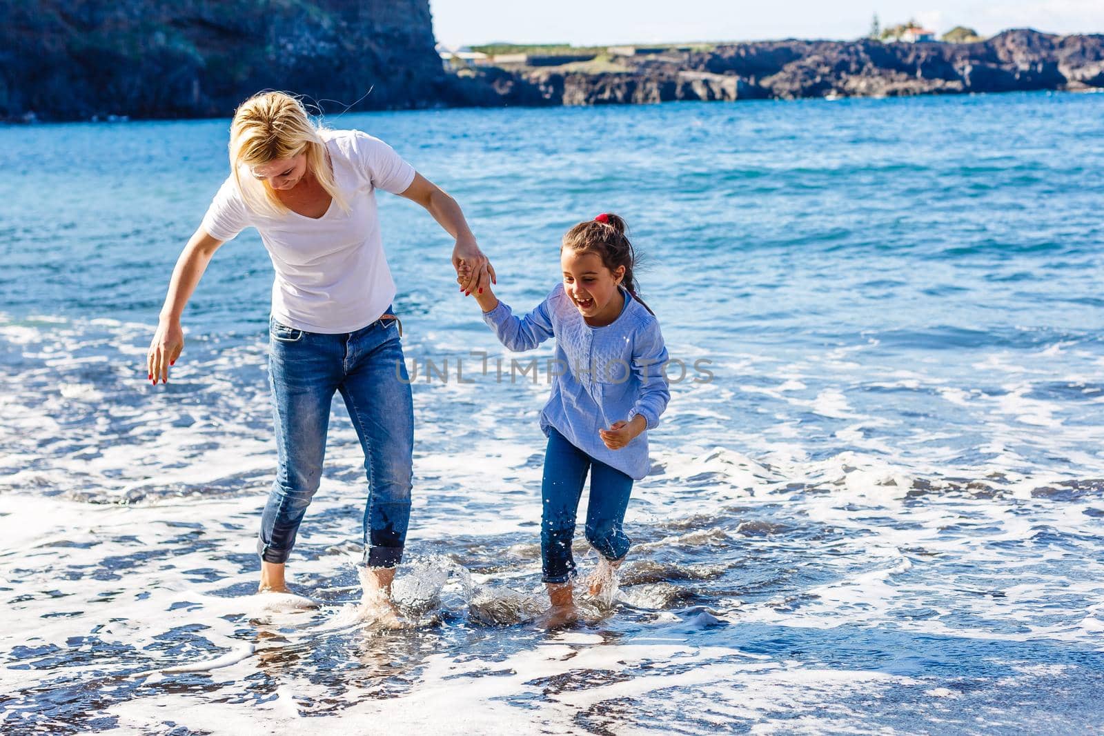 Family holiday on Tenerife, Spain. Mother with children outdoors on ocean. Portrait travel tourists - mom with kids. Positive human emotions, active lifestyles. Happy young family on sea beach