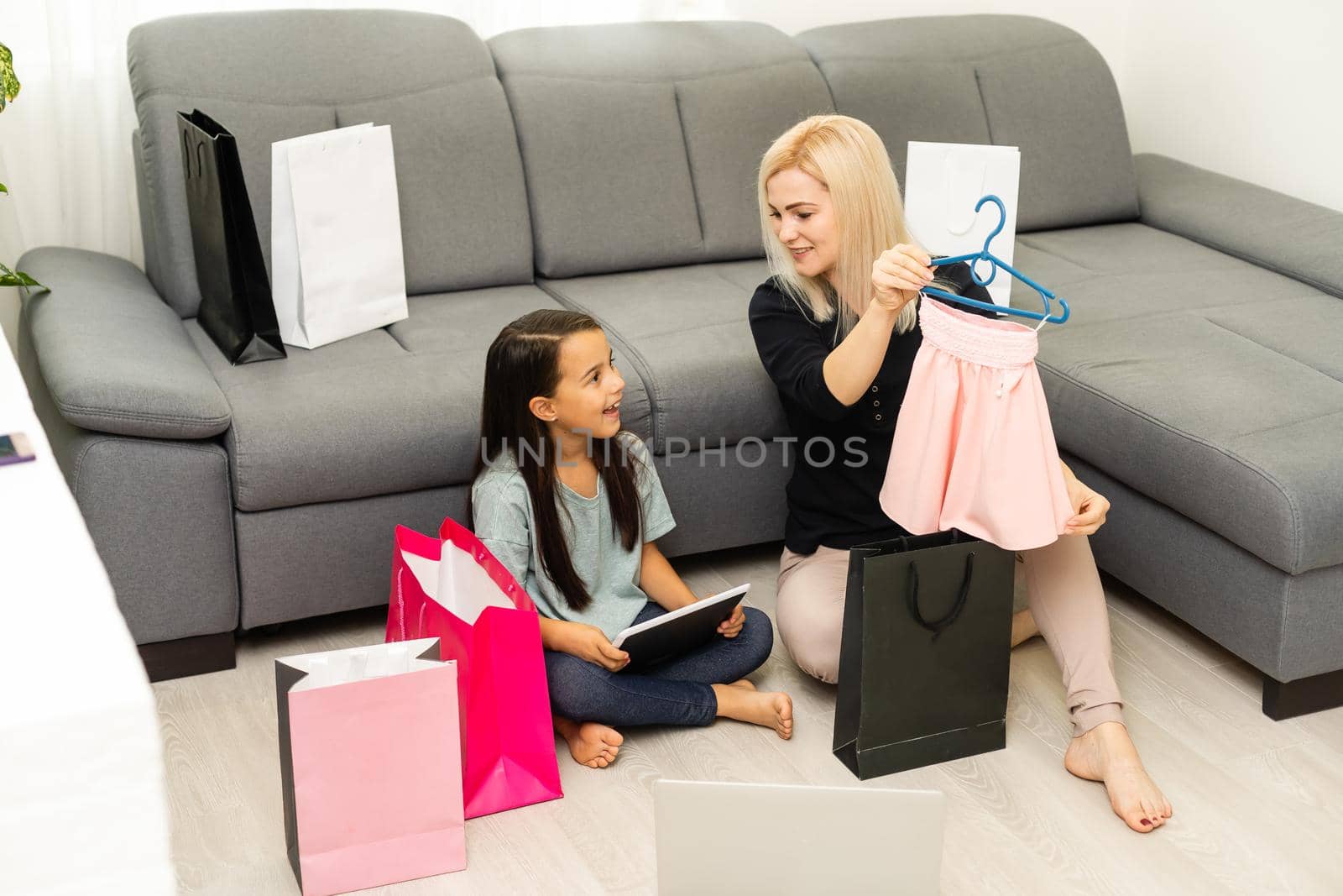 Happy Mother and daughter unpacking shopping bags in the living-room