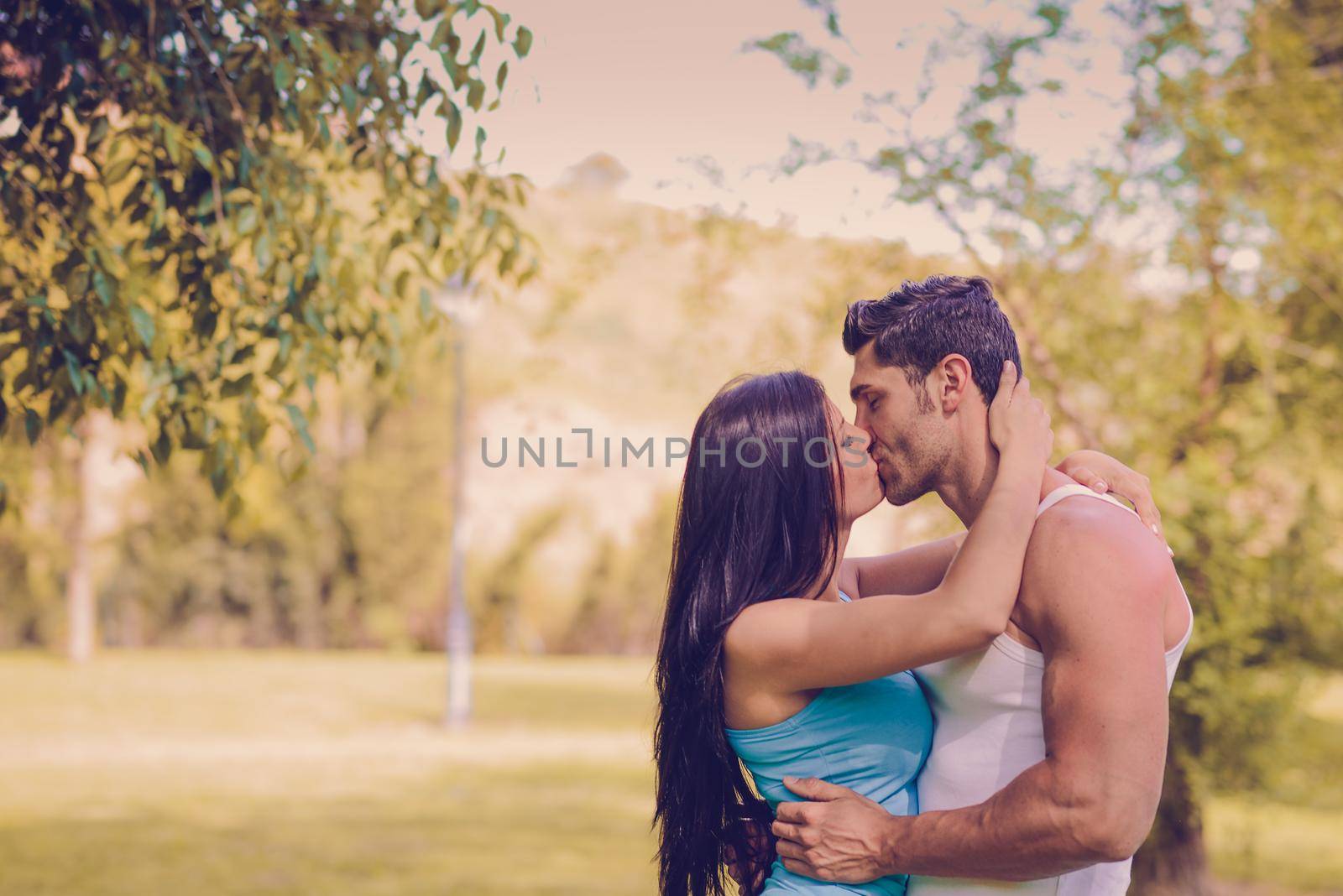 Young couple kissing in a beautiful park by javiindy