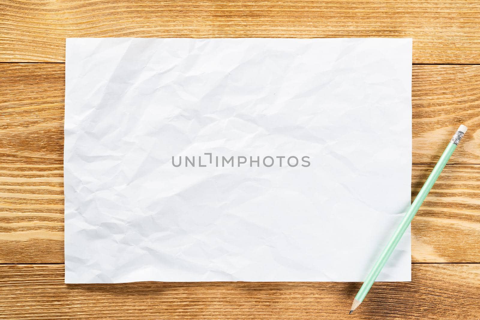 Minimal wooden desk workplace with blank paper. White a4 format paper with pencil. Textured natural wooden background. Vintage copy space for creative design and advertising. Business planning