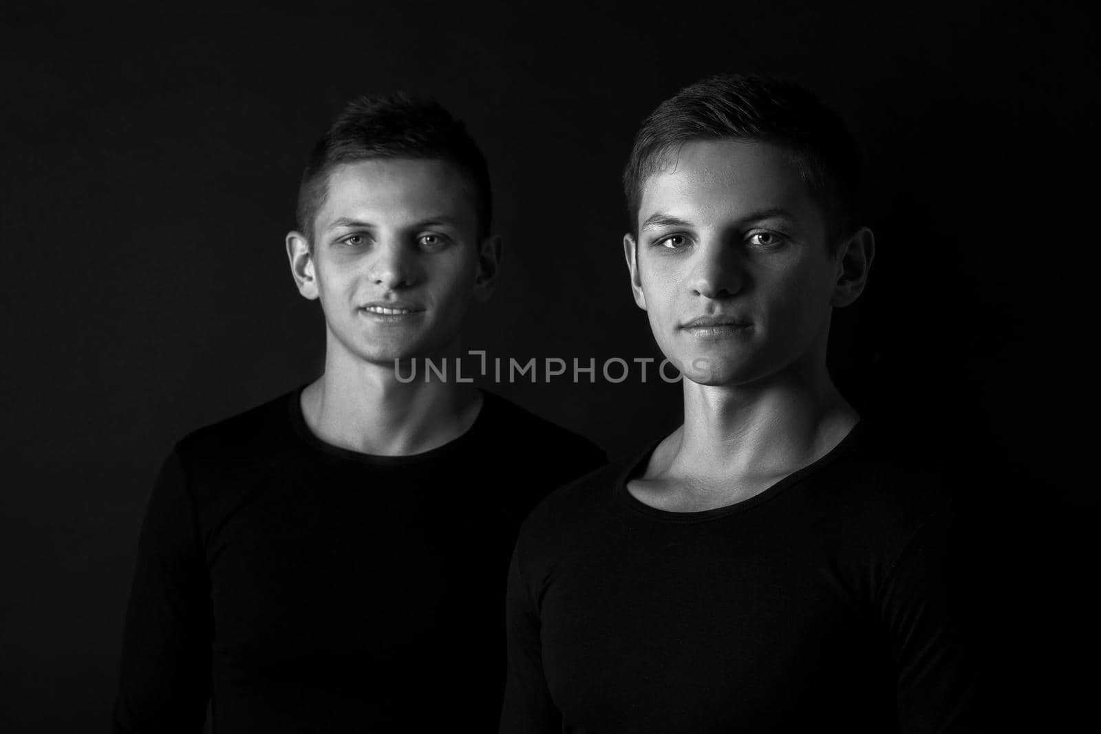Two attractive positive young twin brothers standing dressed in by nazarovsergey