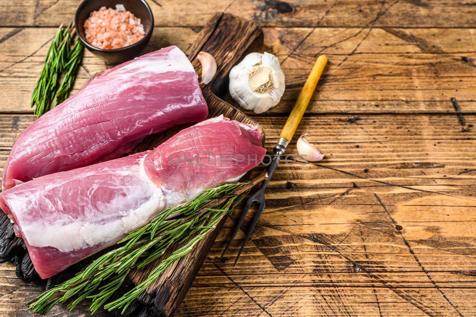 Raw cut pork tenderloin fillet meat. wooden background. Top view. Copy space by Composter