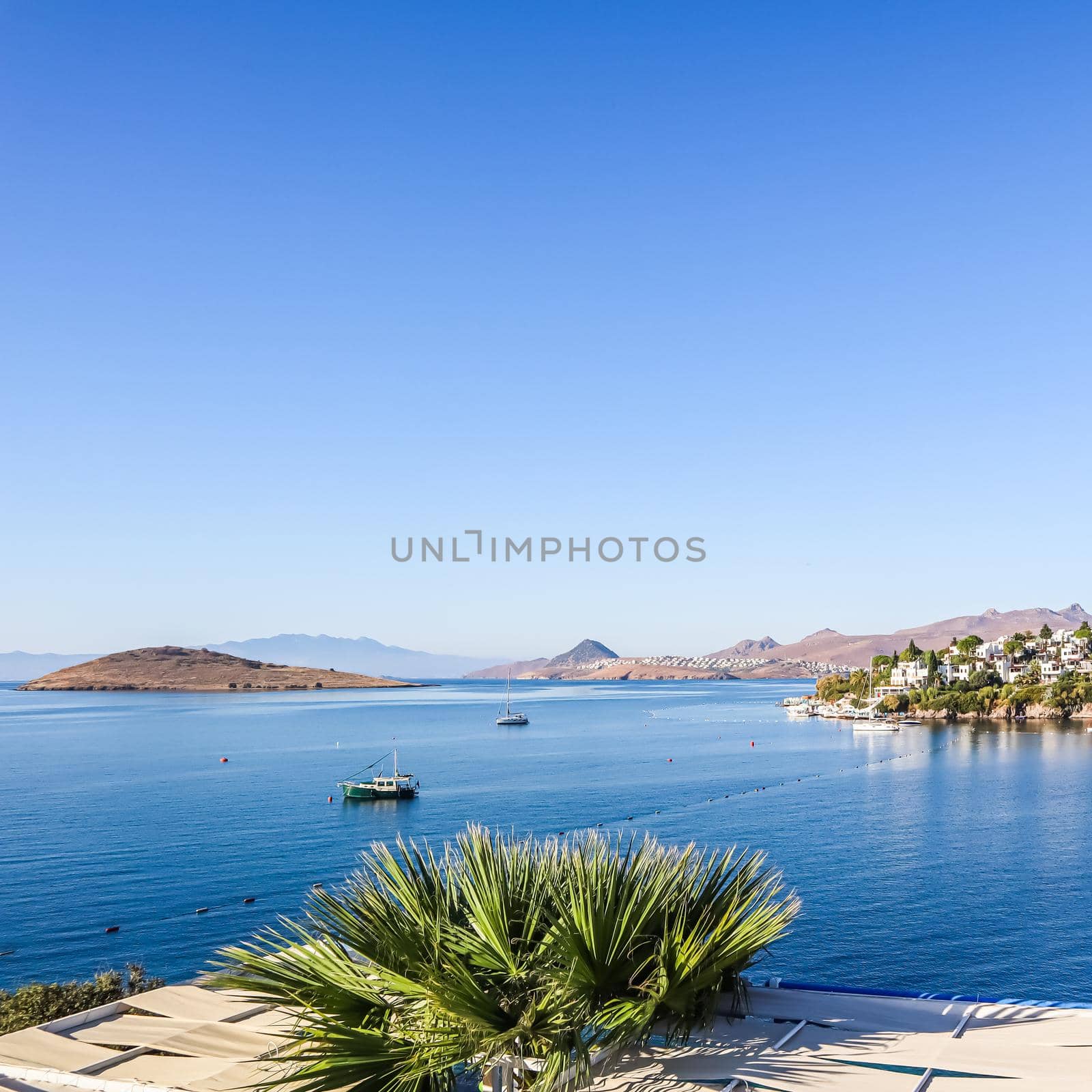 Aegean coast with marvelous blue water, rich nature, islands, mountains and small white houses.