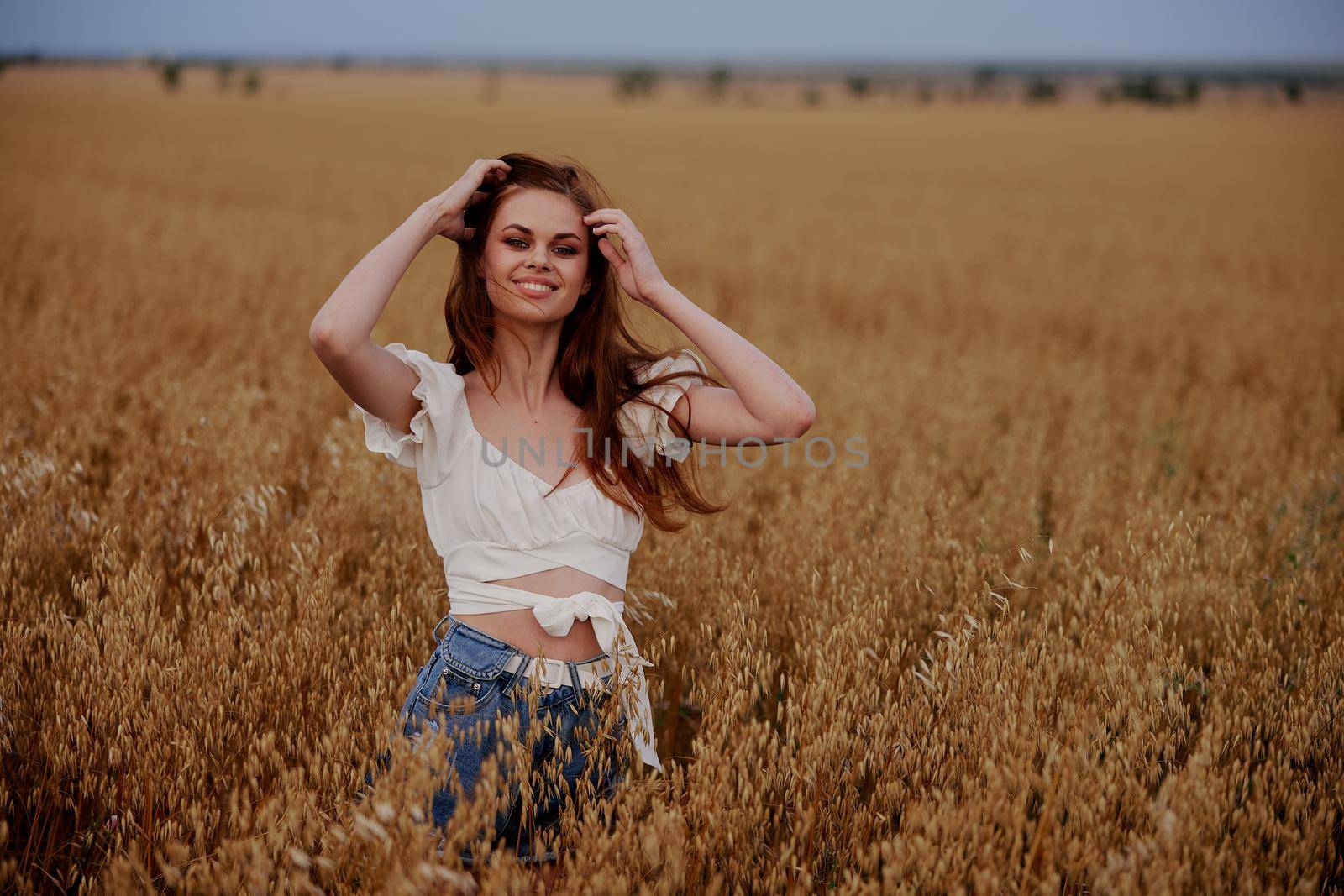 smiling woman standing in a field in nature wheat agriculture landscape. High quality photo