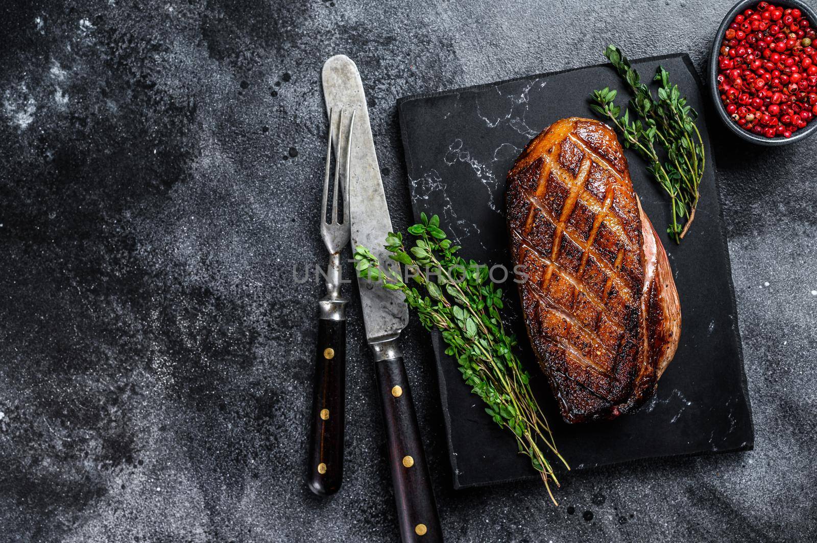 Roasted Christmas duck breast fillet steak. Black background. Top view. Copy space.