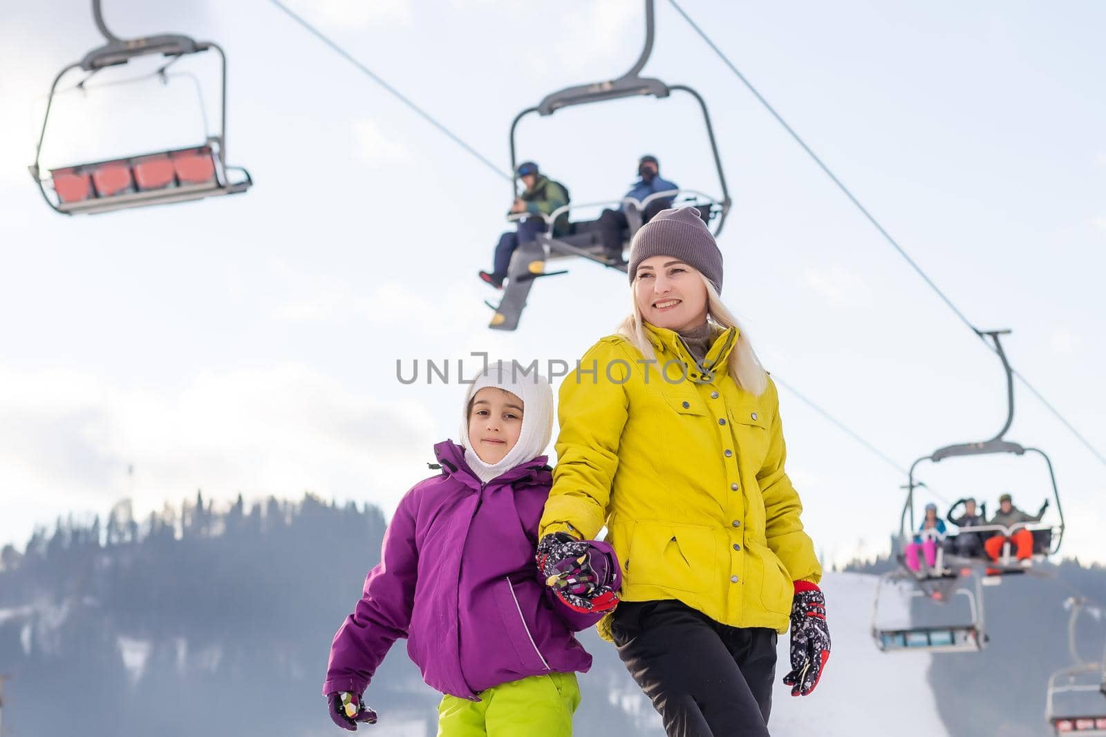 Mother and daughter with snowboards are playing in the snow