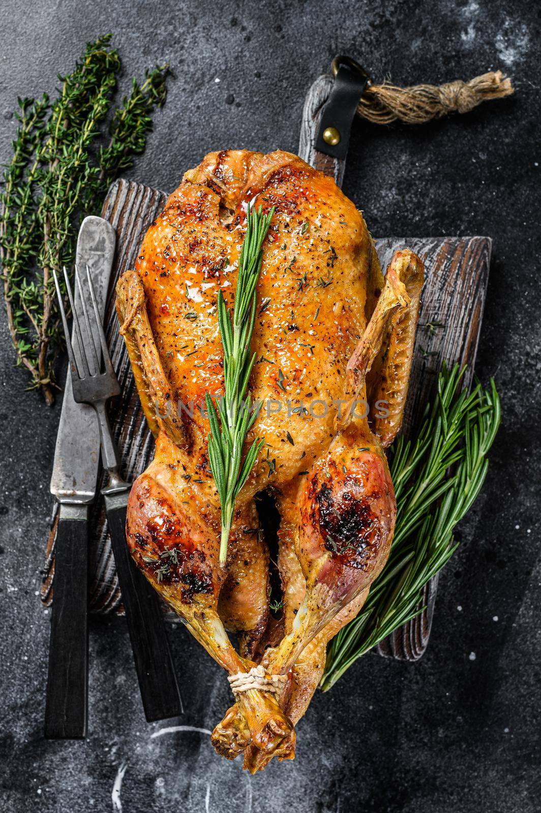 Roast duck stuffed with baked apples, festive christmas recipe. Black background. Top view by Composter