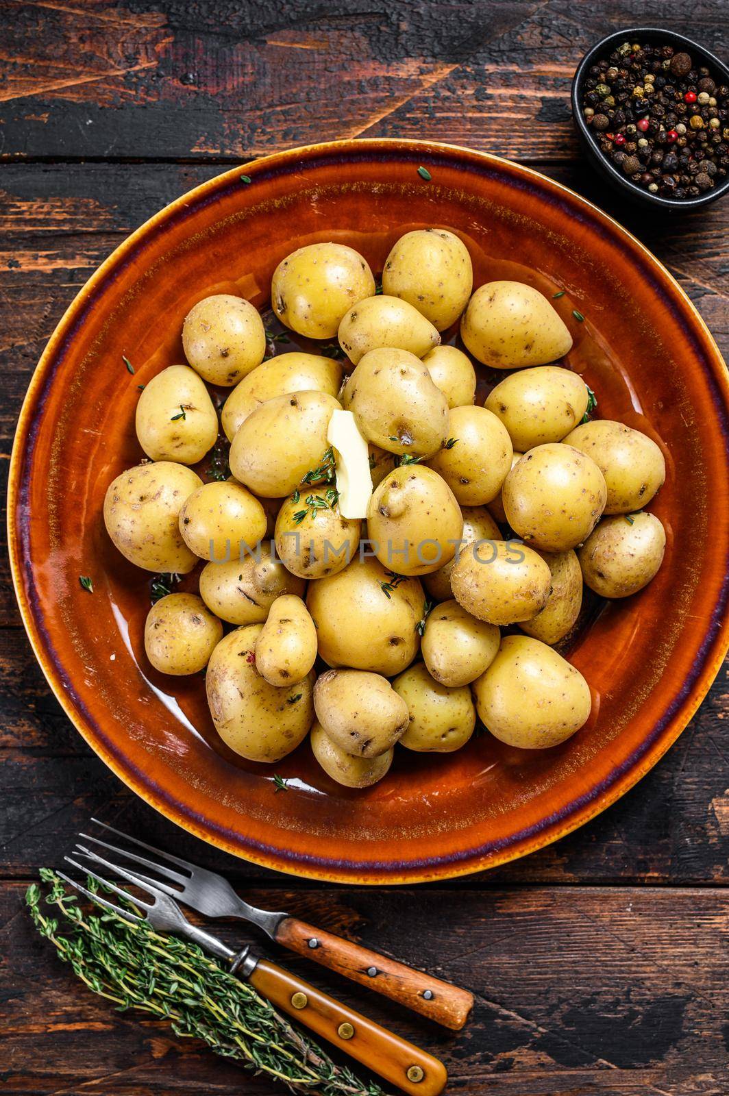 New young boiled potato with butter and chopped dill. Dark Wooden background. Top view by Composter