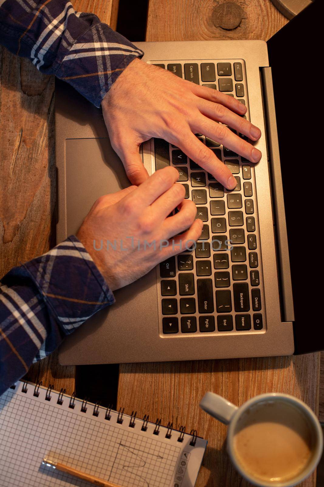 Young man drinking coffee in cafe and using laptop. Man's hands using laptop during coffee break by nazarovsergey