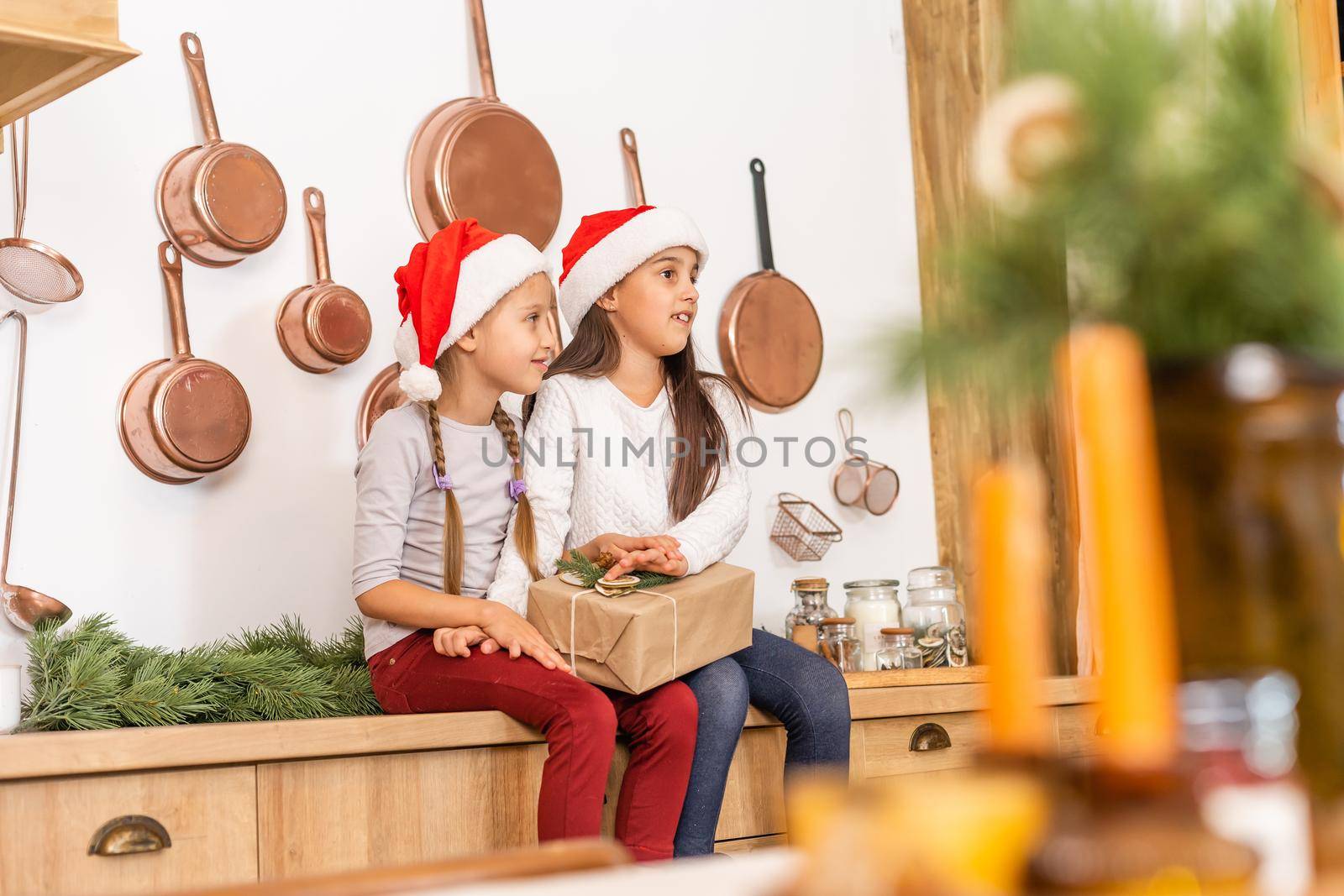 Two cute girls are holding gift boxes in their hands in a Christmas interior. Christmas and New Year concept