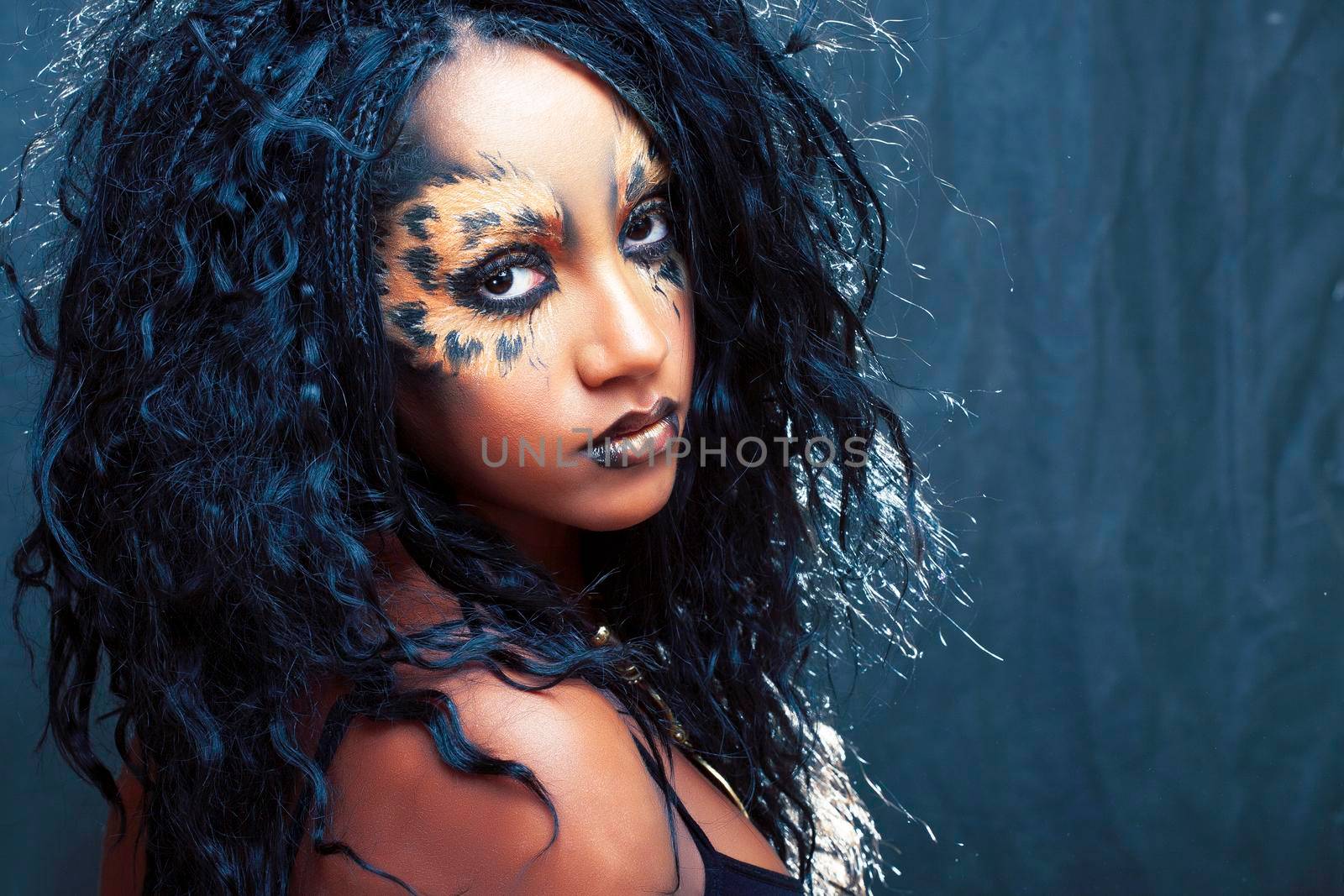 beauty afro girl with cat make up, creative leopard print on face closeup halloween woman concept