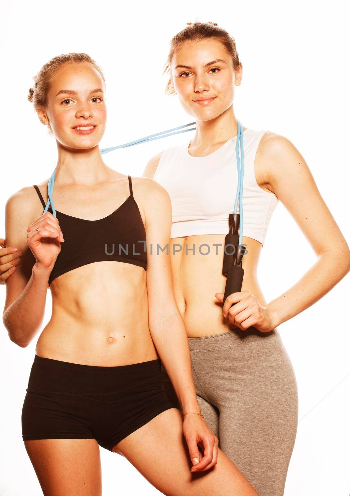 two sport girls measuring themselves isolated on white by JordanJ