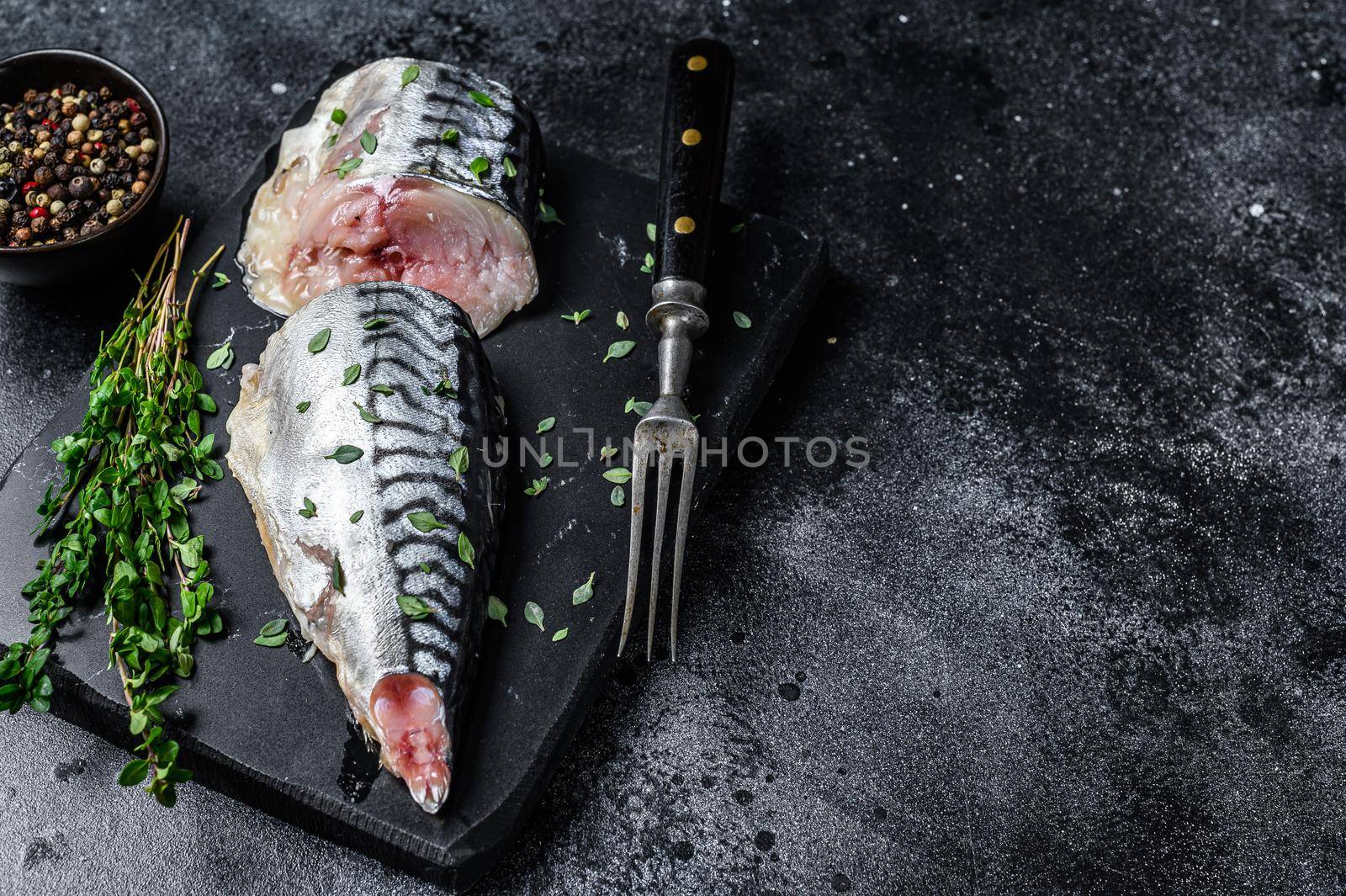 Cold smoked mackerel fish with herbs. Black background. Top view. Copy space by Composter