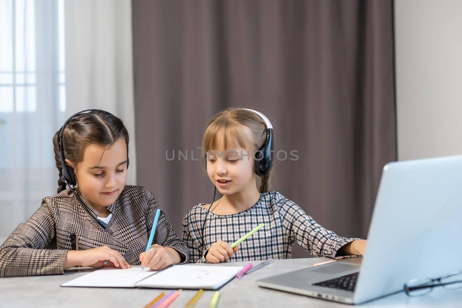 Portrait of two person nice-looking attractive charming cute lovely positive funny cheerful cheery girls researching subject browsing doing homework in light white interior class room indoors