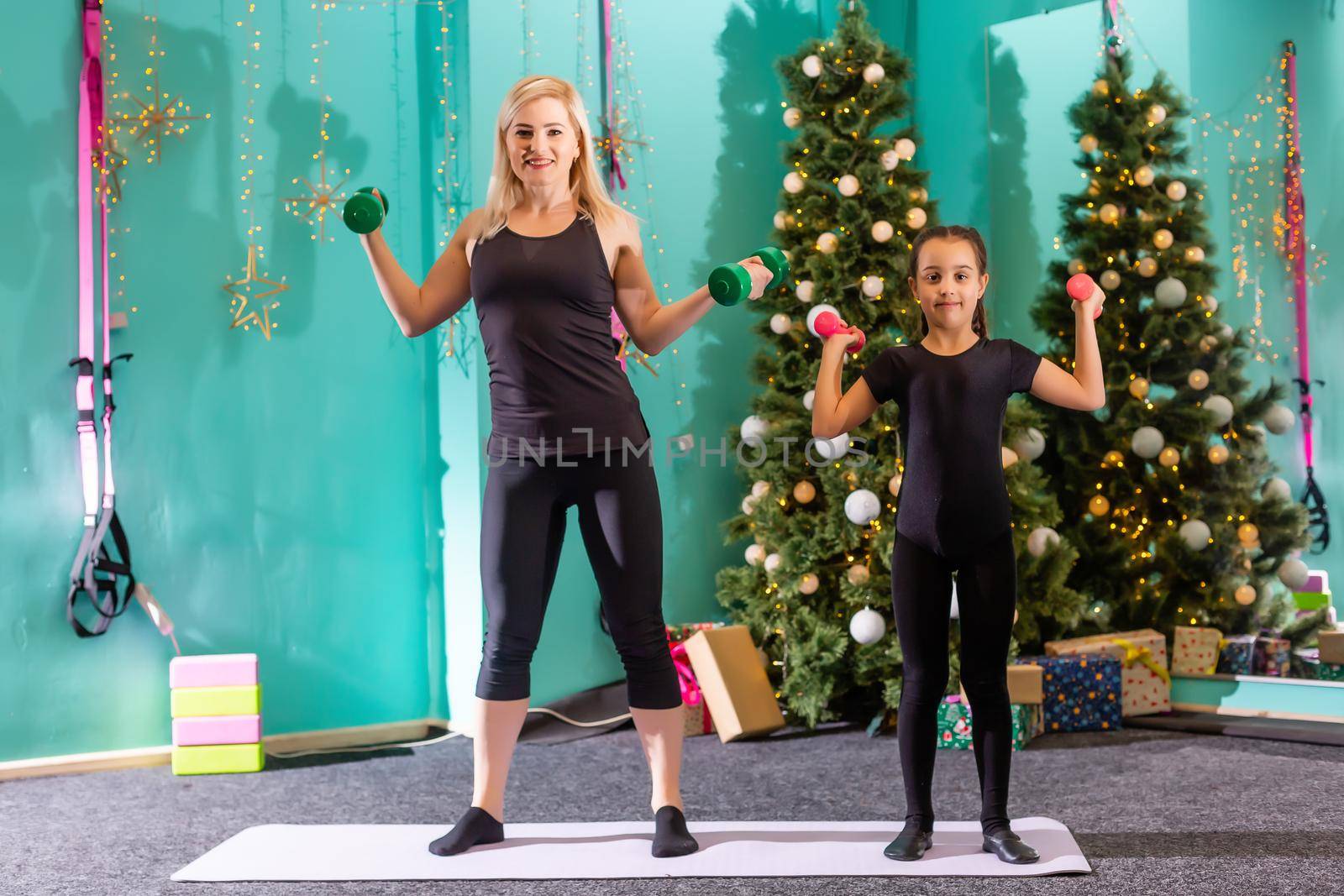 family doing fitness near the christmas tree by Andelov13