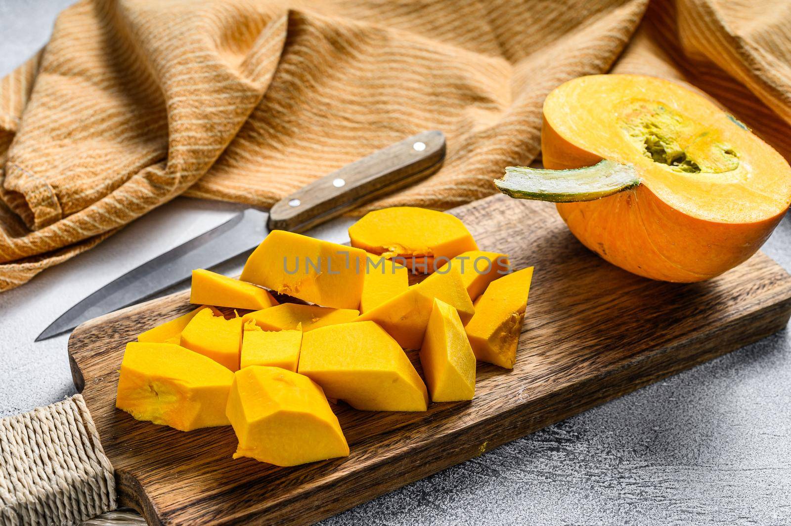 Raw pumpkin cubes on a cutting Board. White background. Top view by Composter