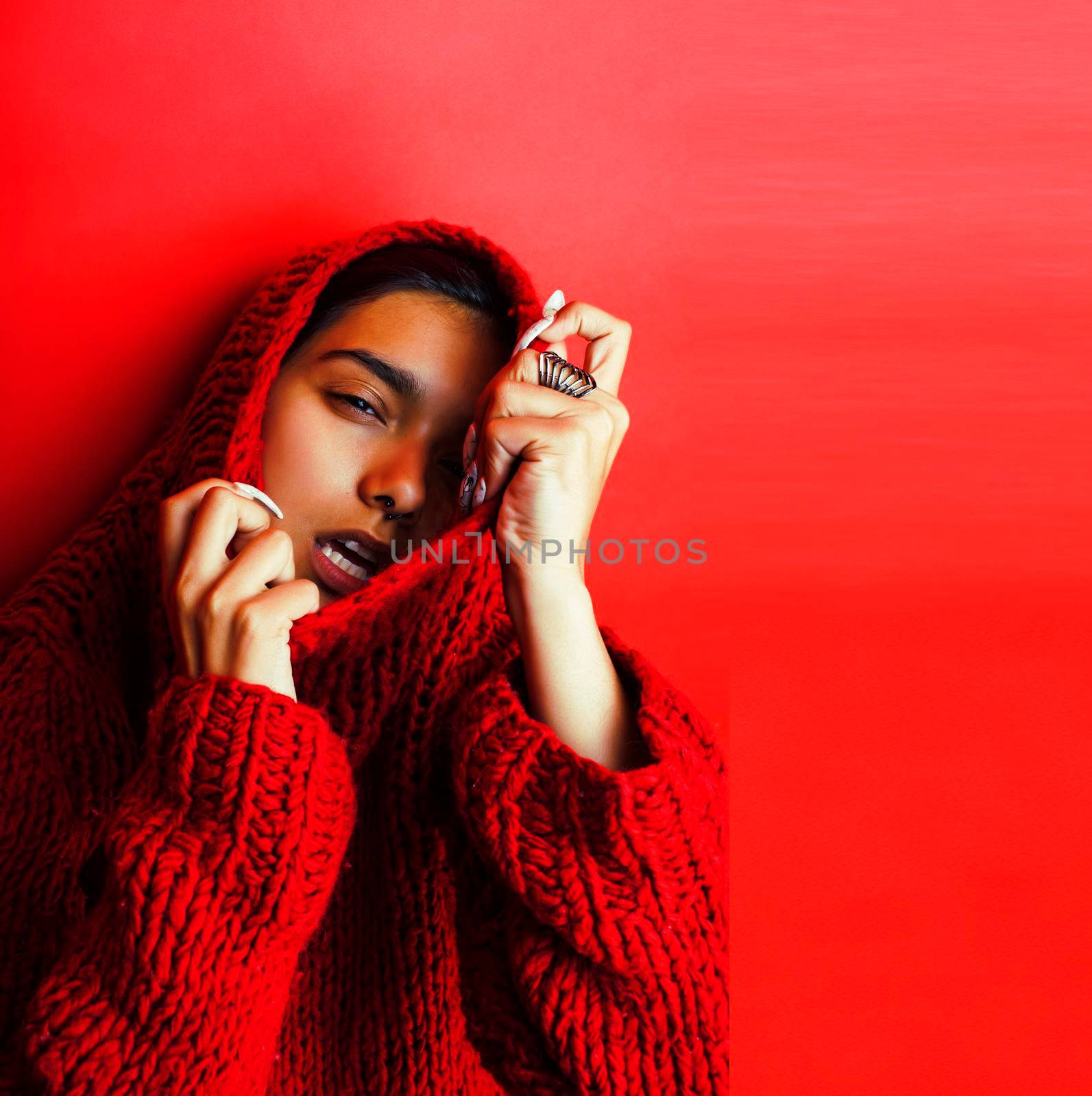 young pretty indian girl in red sweater posing emotional, fashion hipster teenage, lifestyle people concept closeup