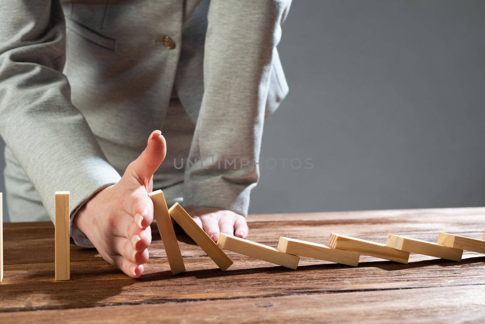 Business woman hand stop domino effect. Operative business solution, strategy and successful intervention. Life insurance company presentation with wooden blocks. Protection from economic crisis.