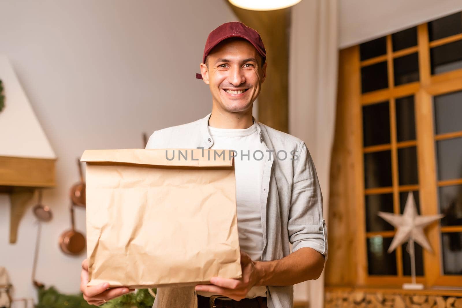 Young delivery man holding and carrying a cardbox. Buy food online in quarantine concept.