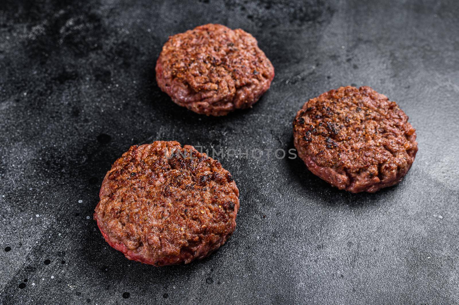 Grilled ground beef steak patties for burgers, Mince meat. Black background. Top view.