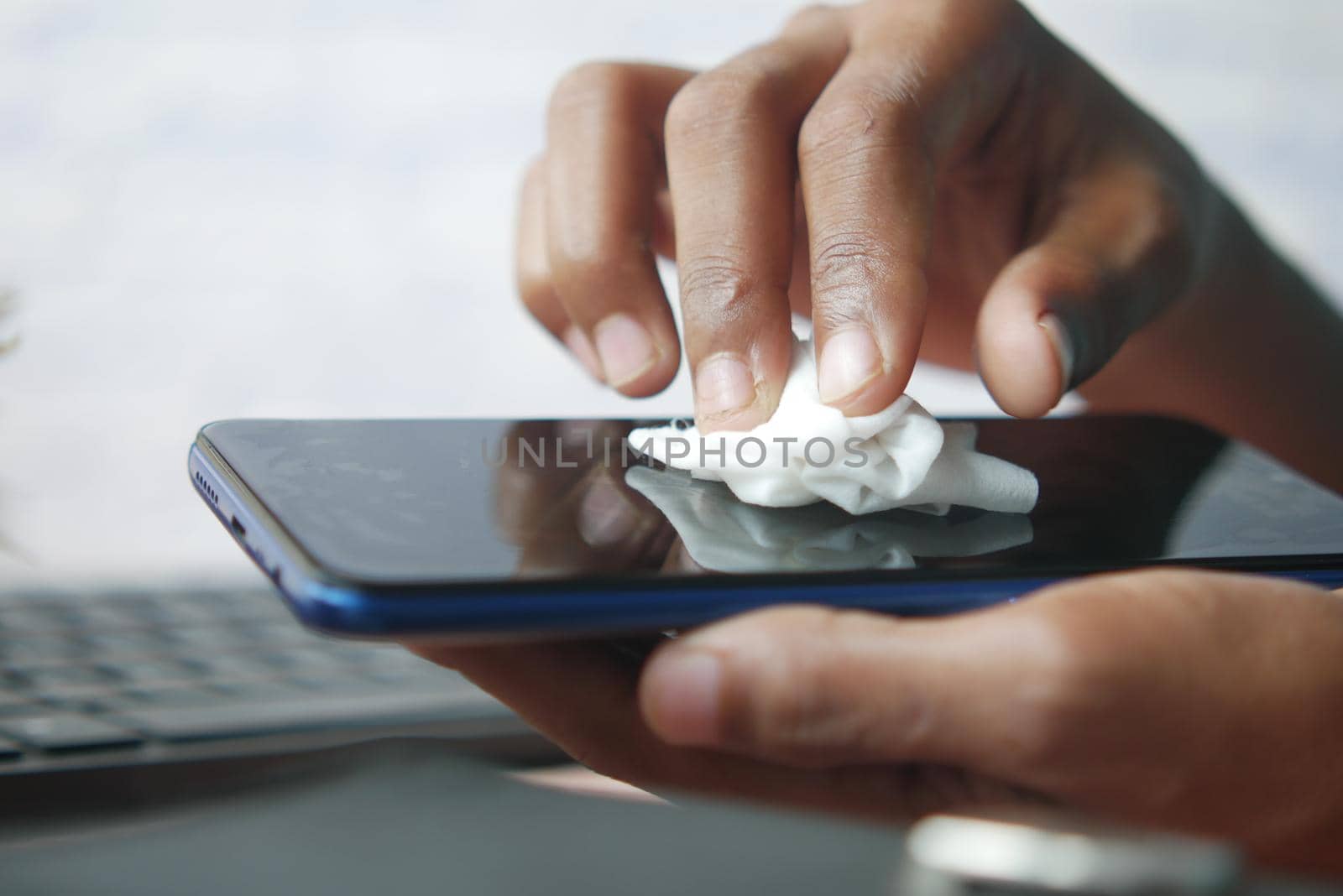 man hand cleaning mobile phone display