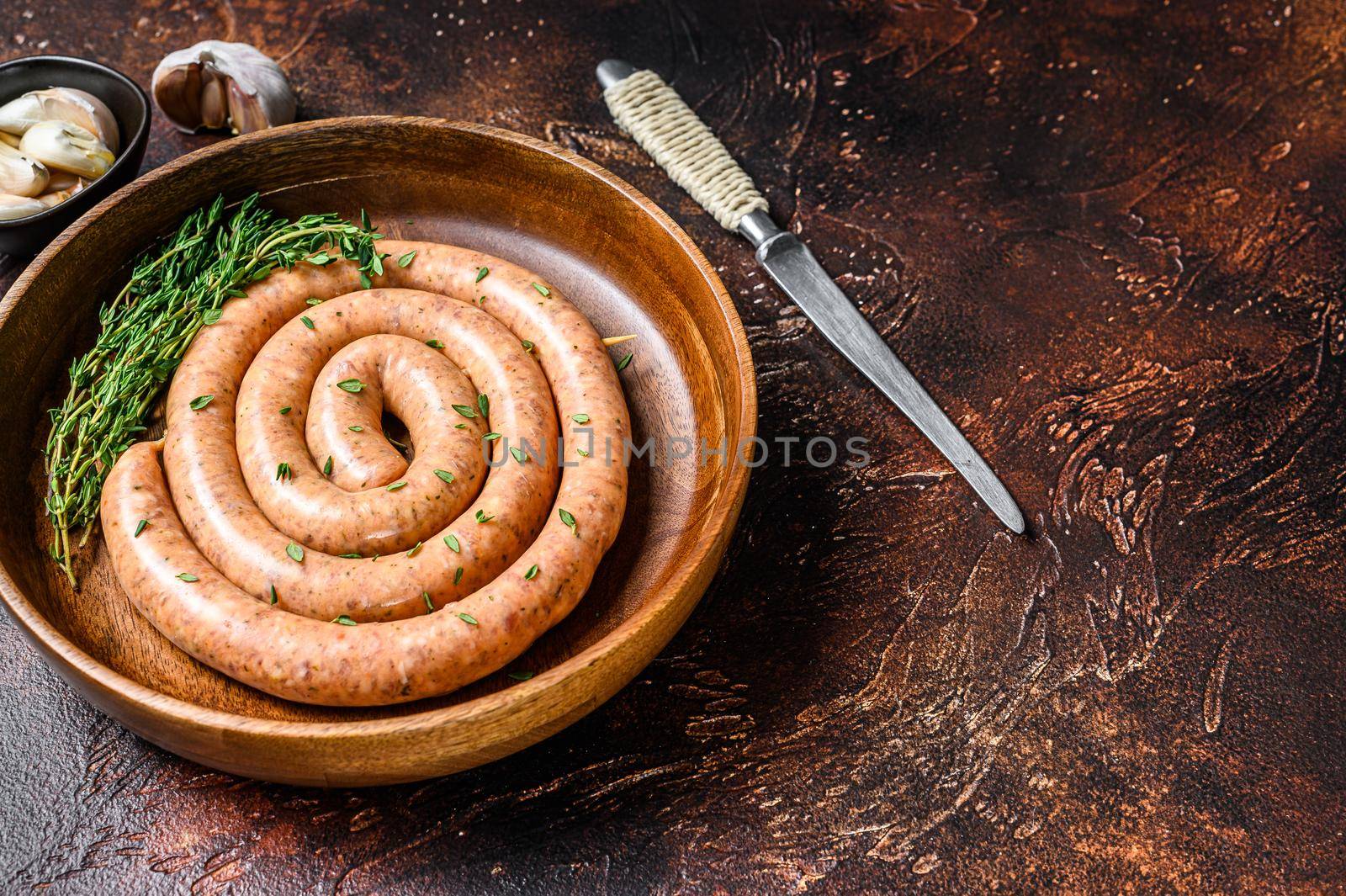 Raw spiral bbq chicken meat sausage. Dark background. Top view. Copy space.