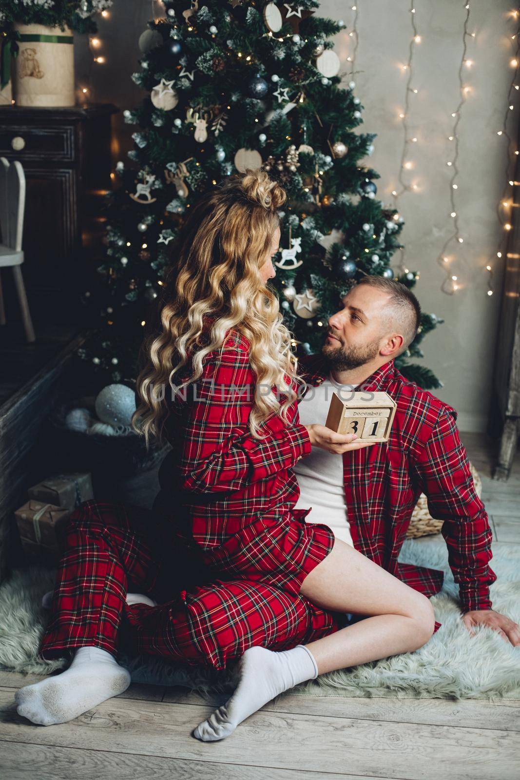 Caucasian woman and her husband relaxes in the living room in christmas atmosphere together.