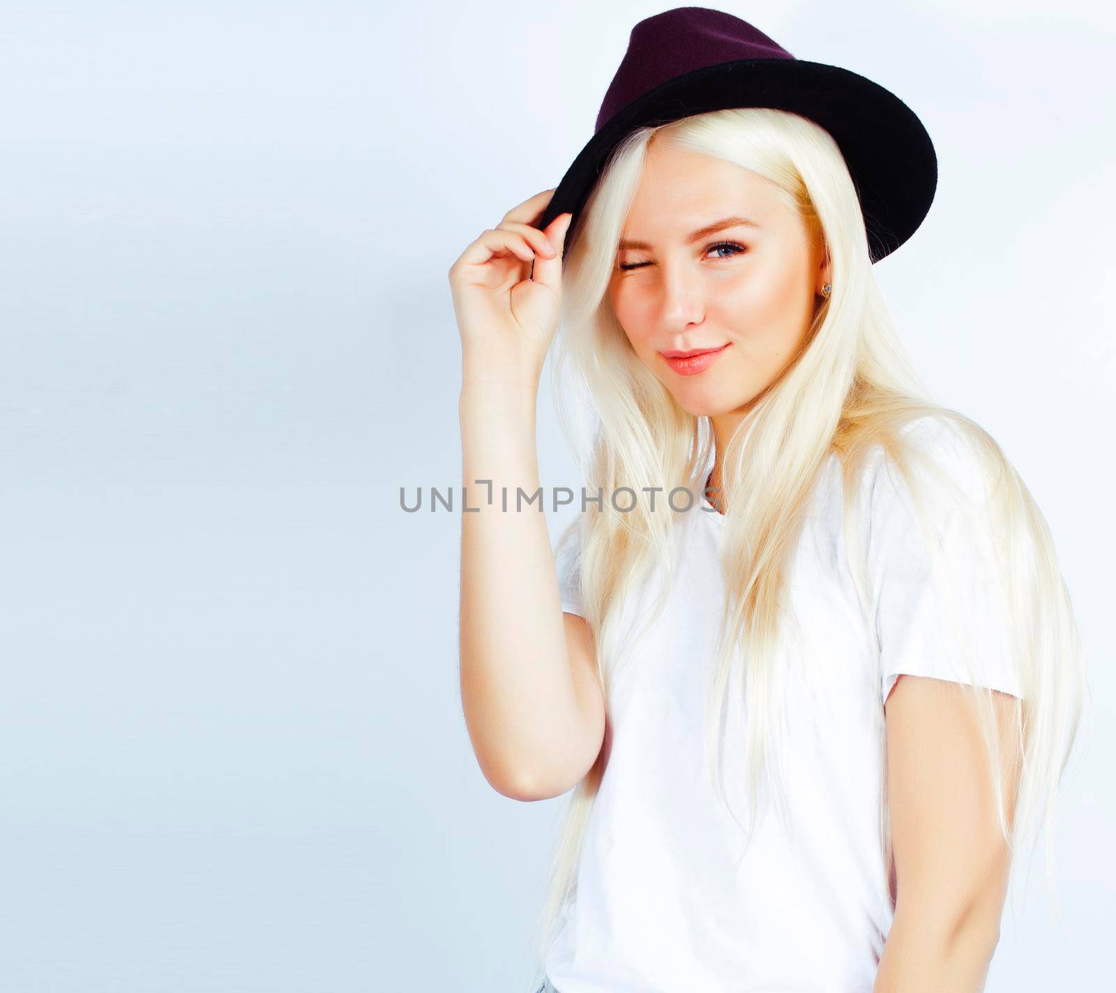 young pretty stylish blond hipster girl in hat posing emotional isolated on white background, lifestyle people concept close up