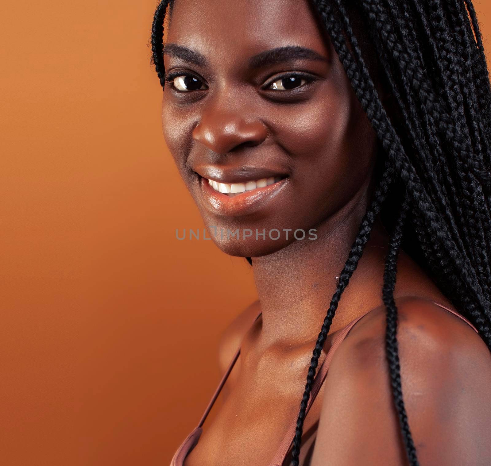 pretty young african american woman with braids posing cheerful gesturing on brown background, lifestyle people concept by JordanJ