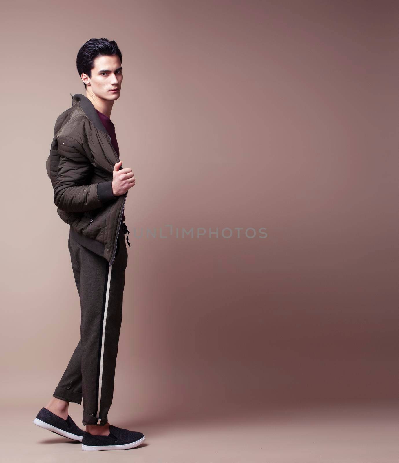 young pretty asian man posing in fashion style on light brown background, lifestyle people concept by JordanJ