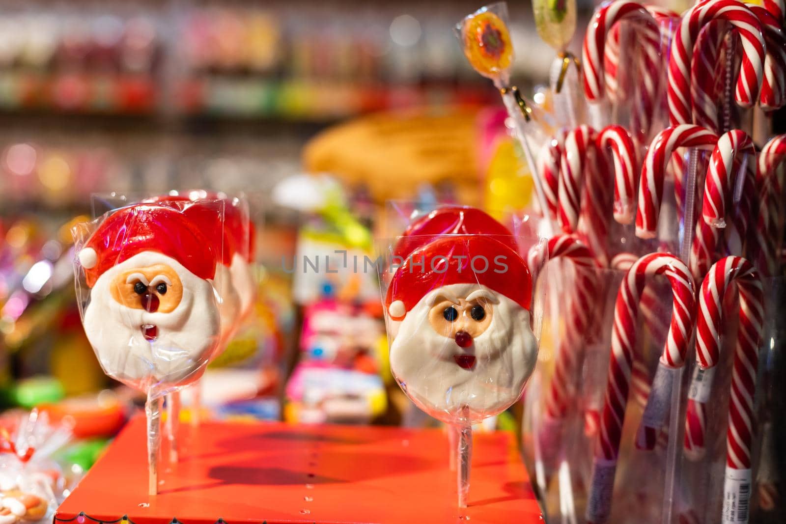 Two lollipops in the shape of Santa Claus on a stick in a transparent film closeup.