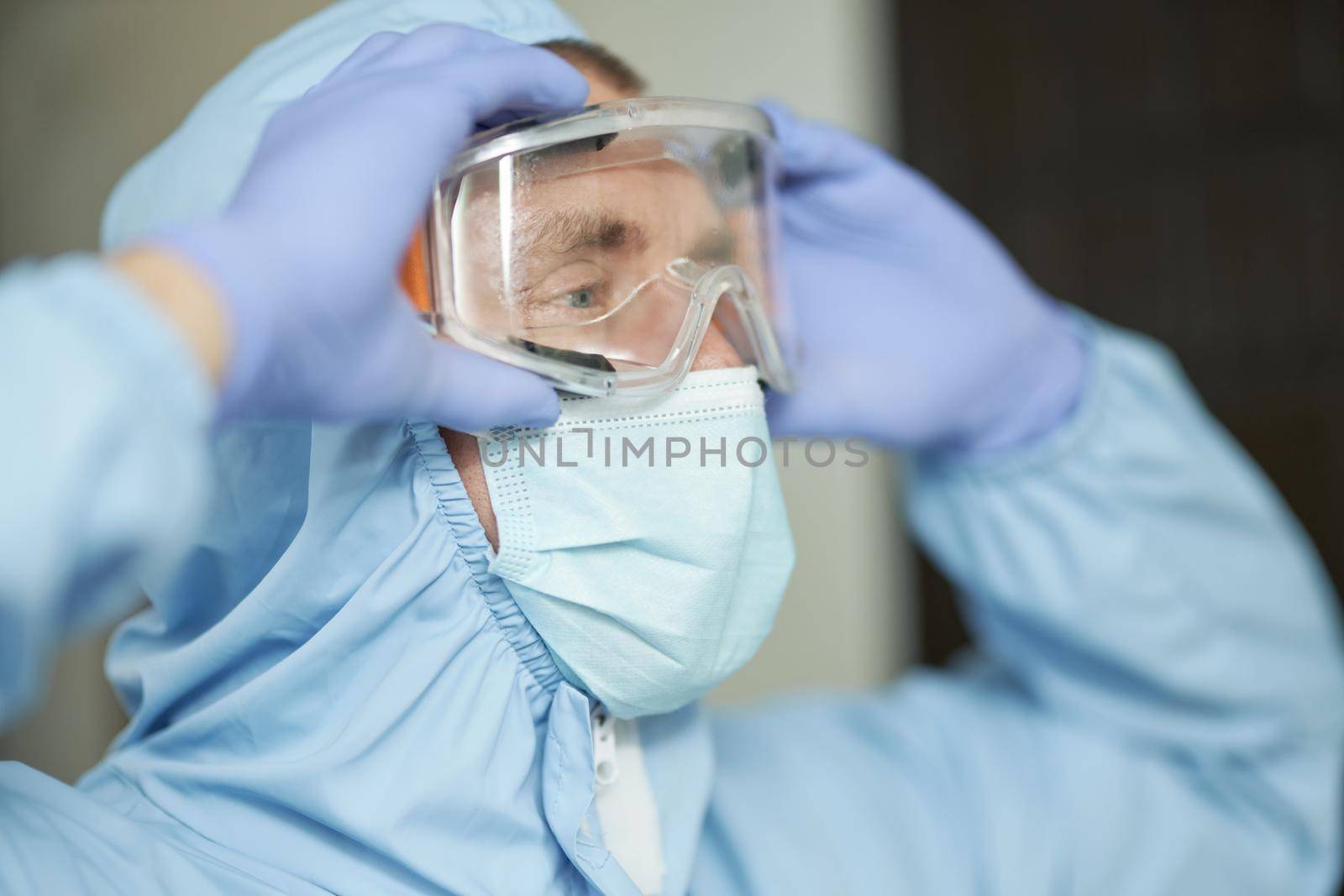 Close up of man wearing protective glasses and suit before disinfection starts. Coronavirus and quarantine concept