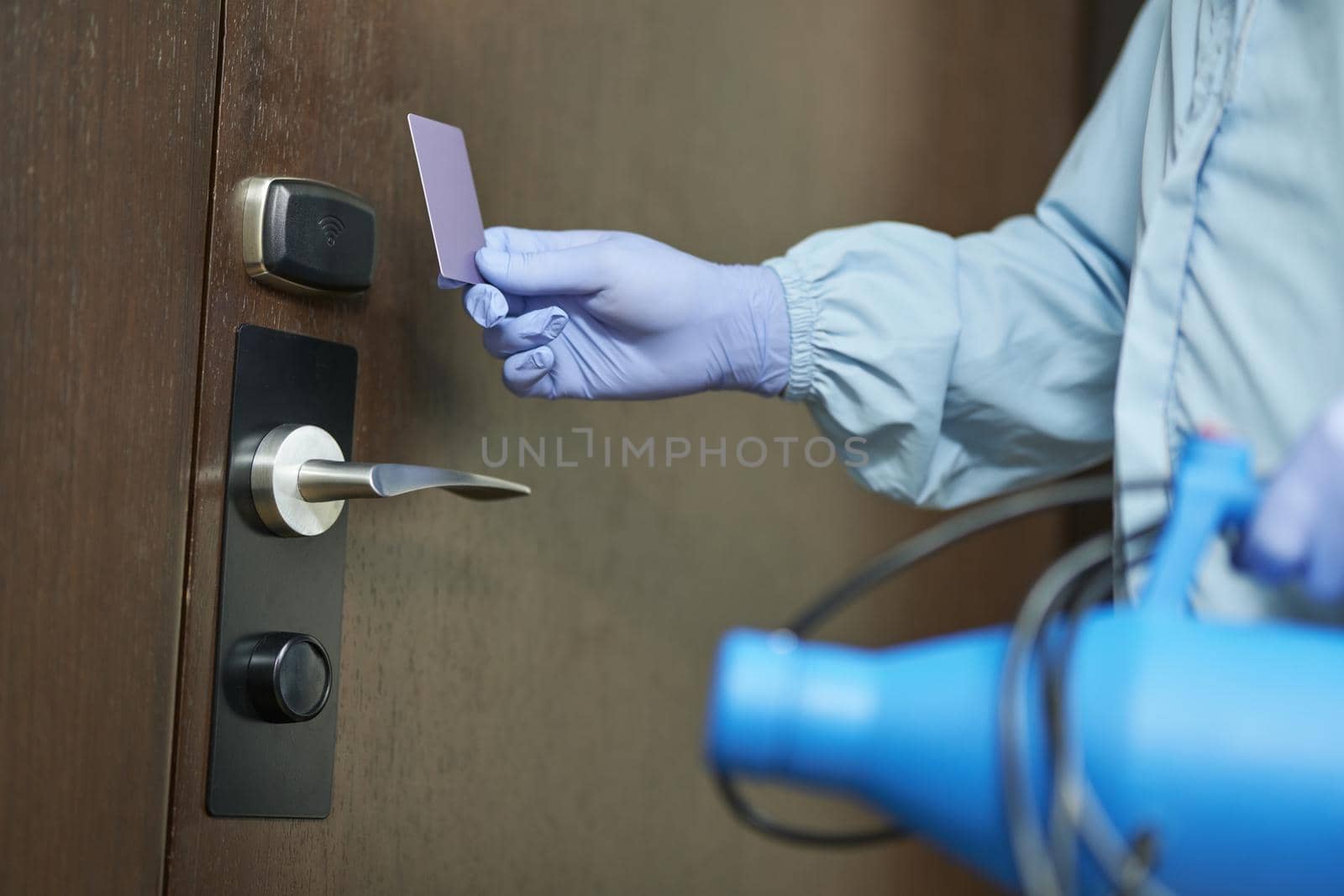 Close up of man protective gloves when going to enter the room and disinfect. Coronavirus and quarantine concept