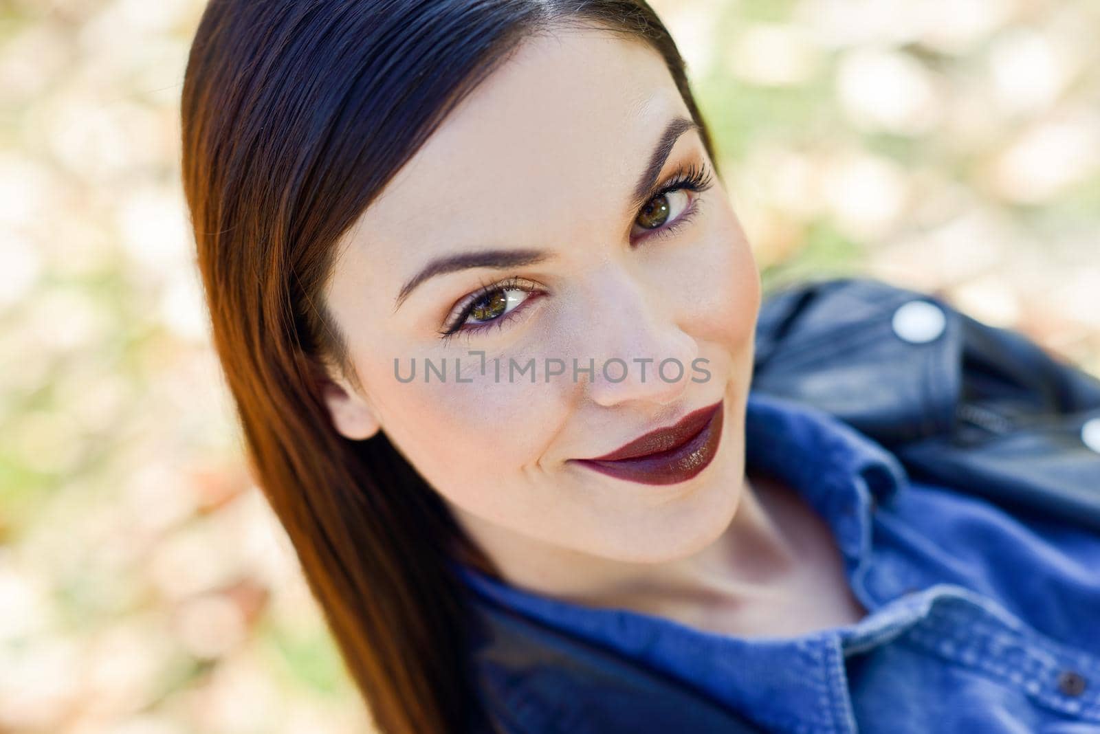 Close-up portrait of brunette young woman, model of fashion, in urban background. Girl with beautiful lips maked-up in red