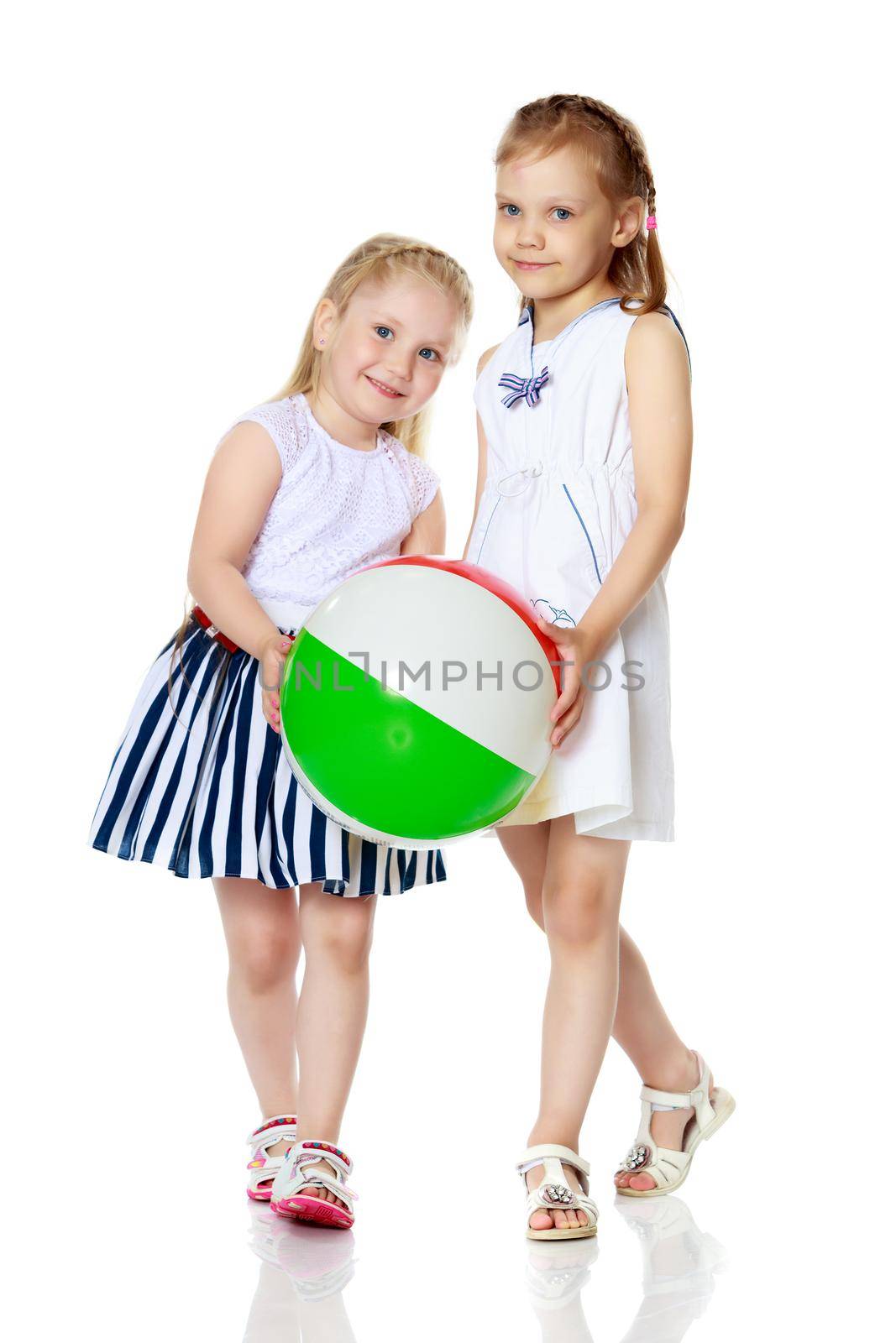 Two little girls are playing with a ball. Game concept, rest on the sea.Isolated on white background.