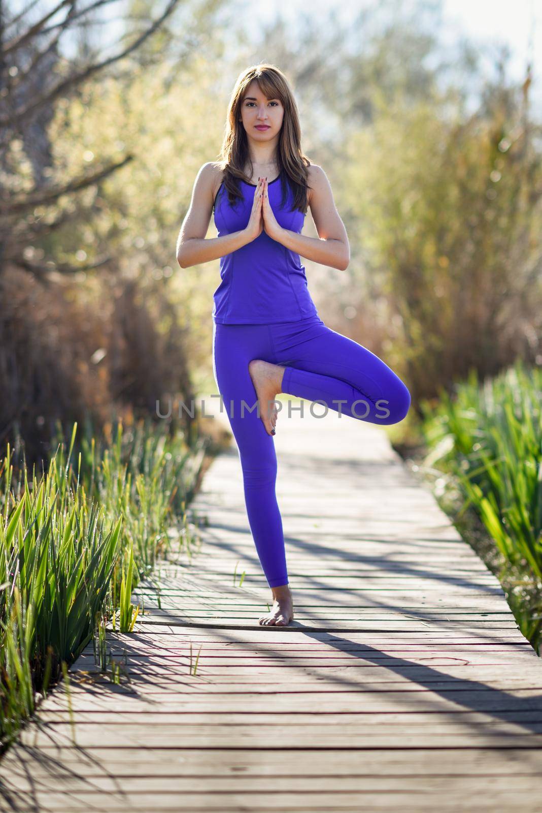 Young beautiful woman doing yoga in nature by javiindy