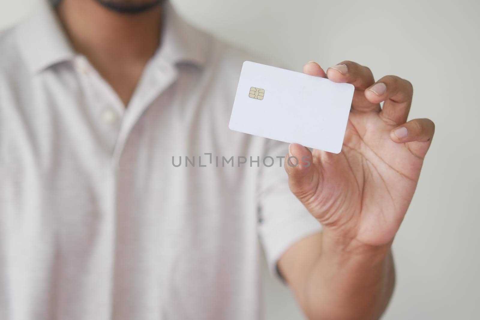 Man in casual dress showing credit card.