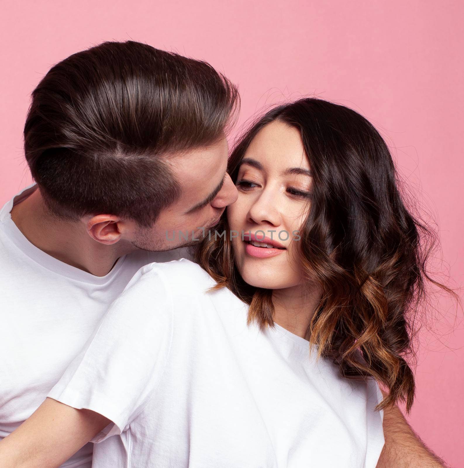 young cheerful caucasian couple together having fun on pink background, guy ang girl modern relationship, lifestyle people concept by JordanJ
