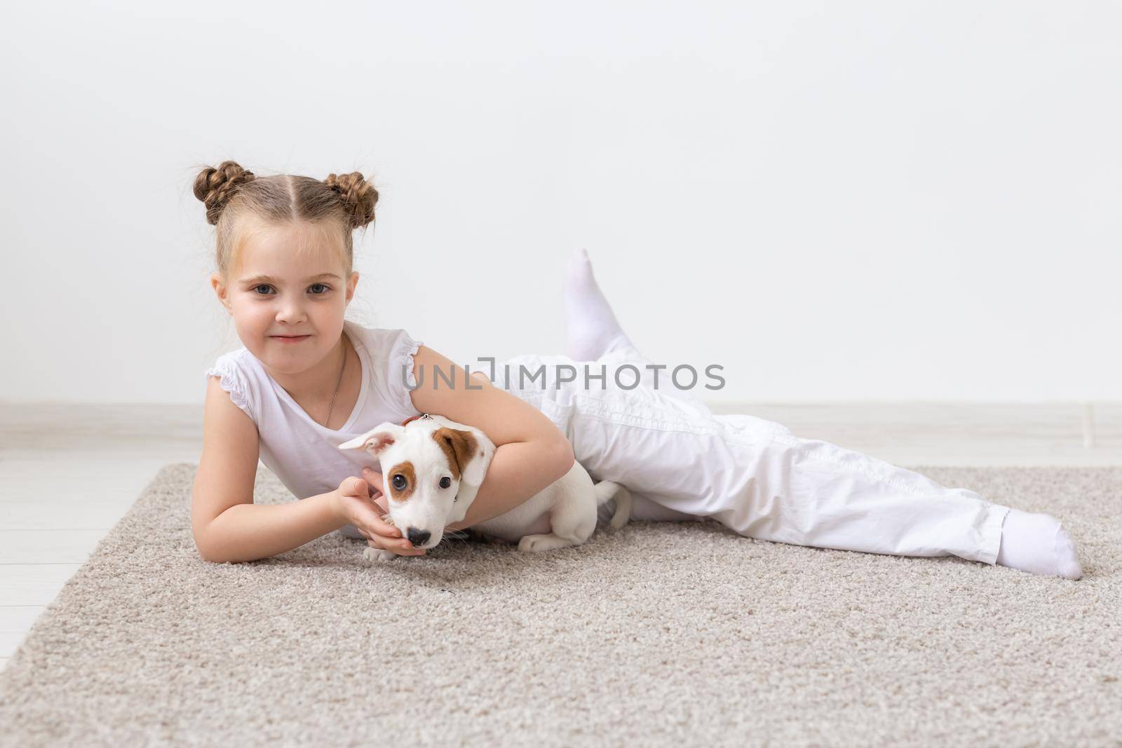 Childhood, pets and dogs concept - Little child girl posing on the floor with puppy by Satura86