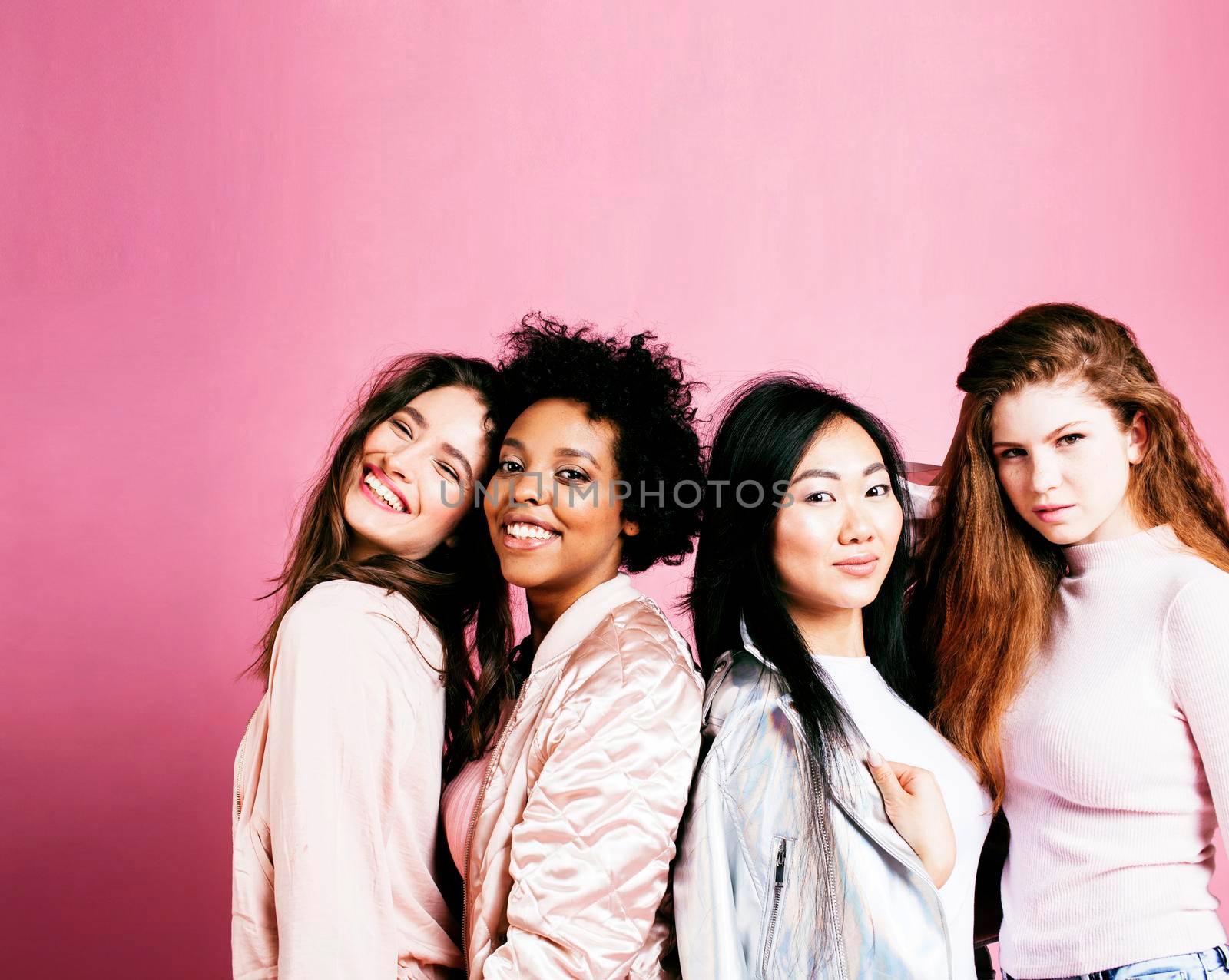 different nation girls with diversuty in skin, hair. Asian, scandinavian, african american cheerful emotional posing on pink background, woman day celebration, lifestyle people concept by JordanJ