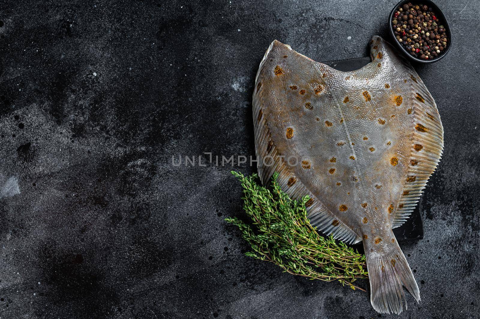 Raw flounder flatfish fish on marble board with thyme. Black background. Top view. Copy space by Composter