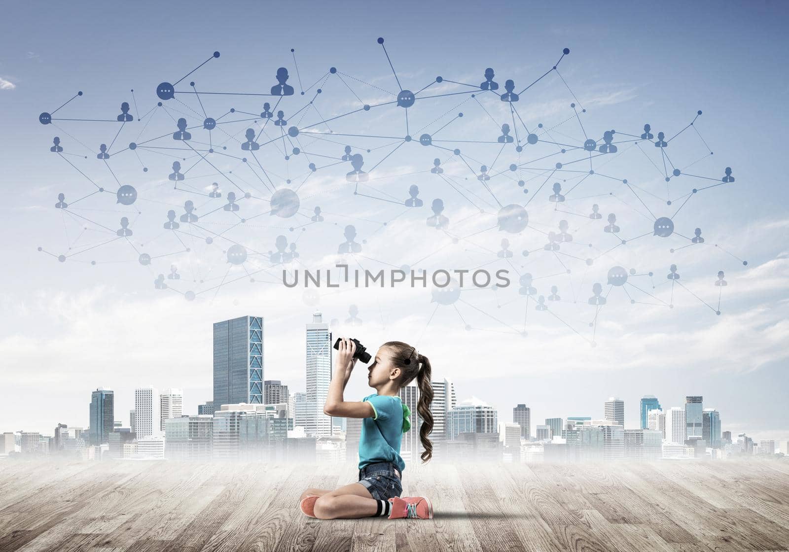 Cute kid girl sitting on wooden floor and looking in binoculars